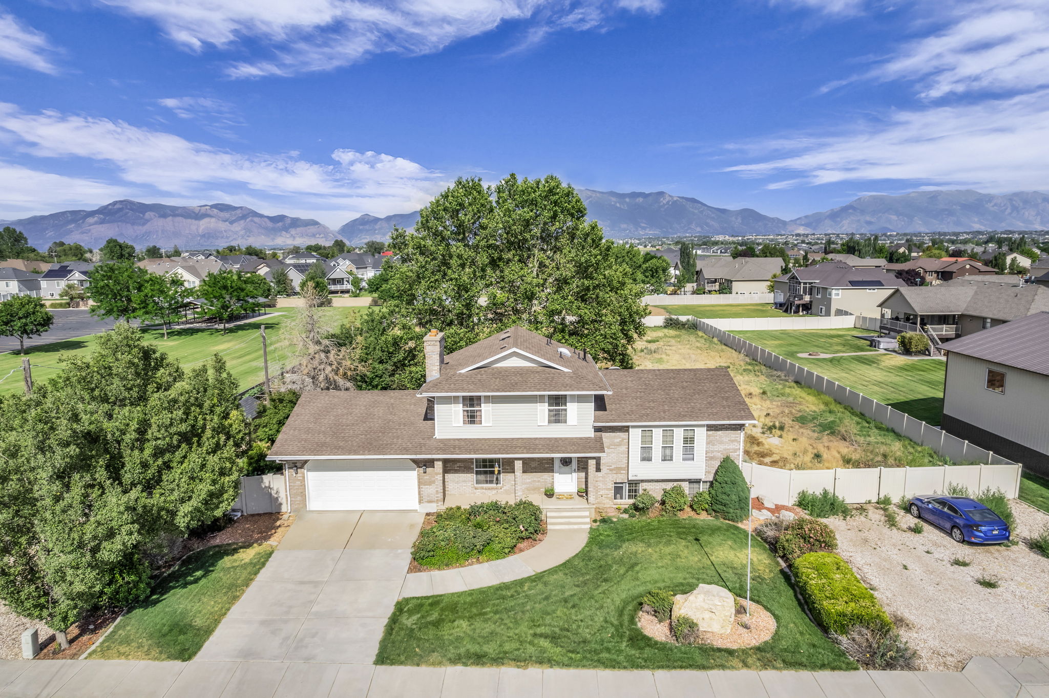 Traditional style home featuring a two-car garage, established front landscaping, and a concrete driveway