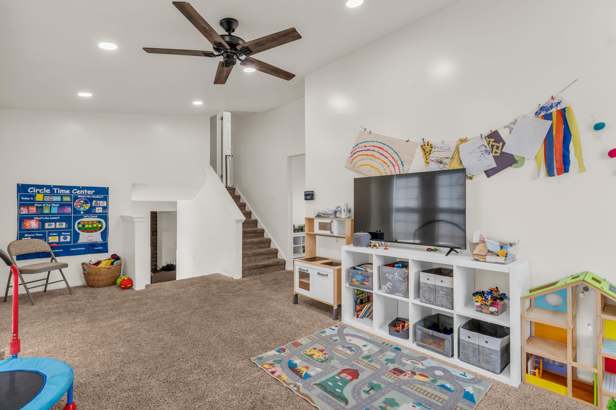 Spacious room featuring plush carpet flooring, a dark wood-finish ceiling fan, and recessed lighting