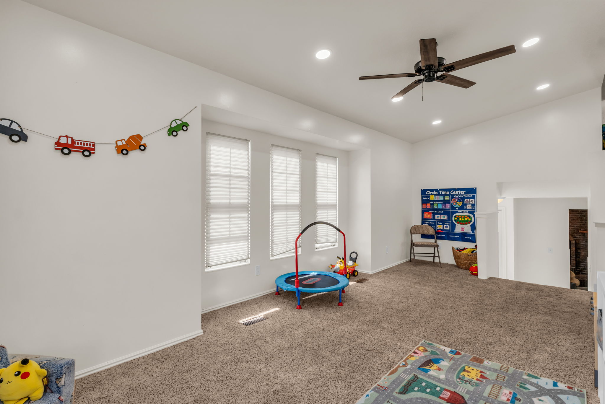 Carpeted secondary room with multiple windows, recessed lighting, and a ceiling fan