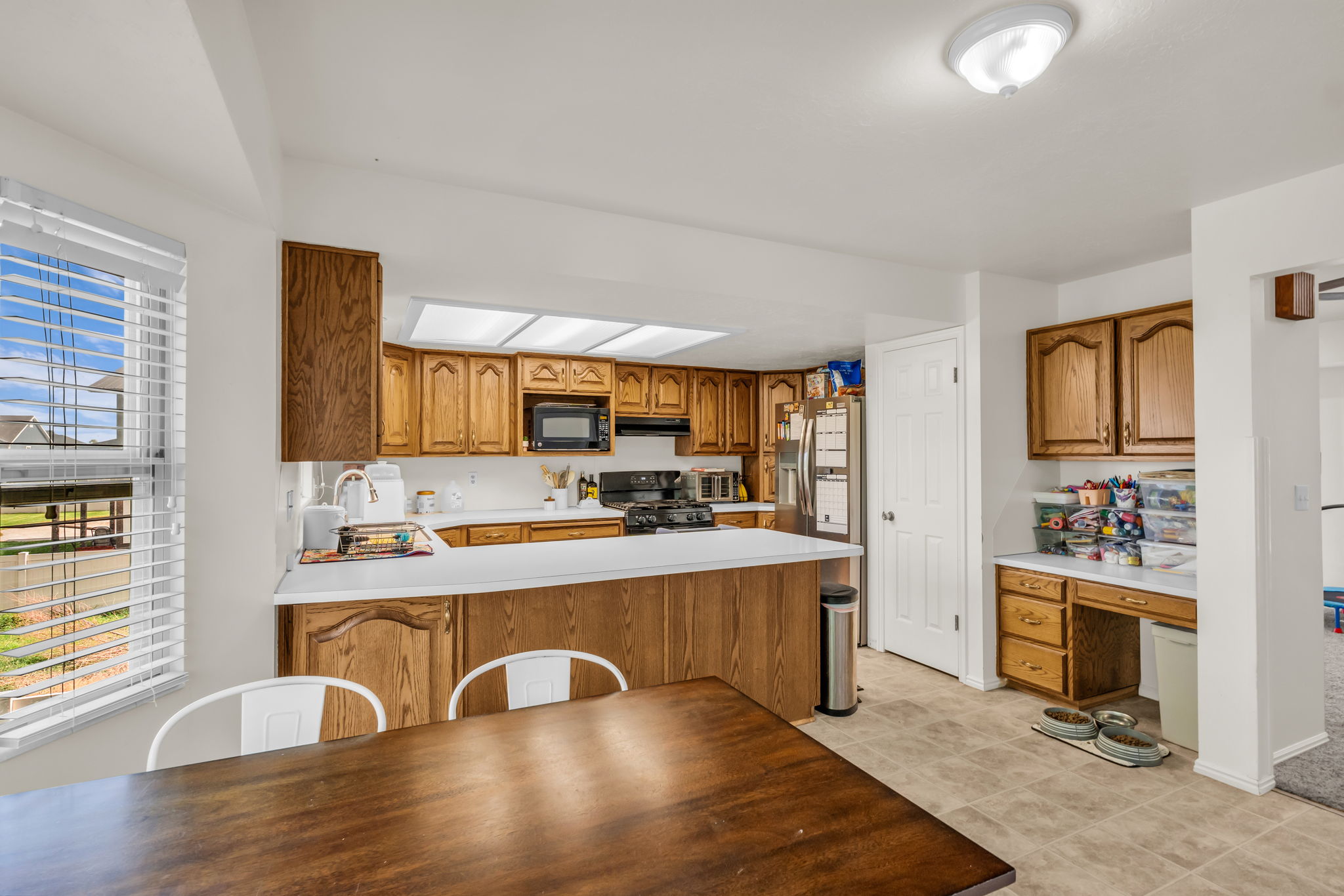 Kitchen featuring wood-finish cabinetry, white countertops, and recessed lighting