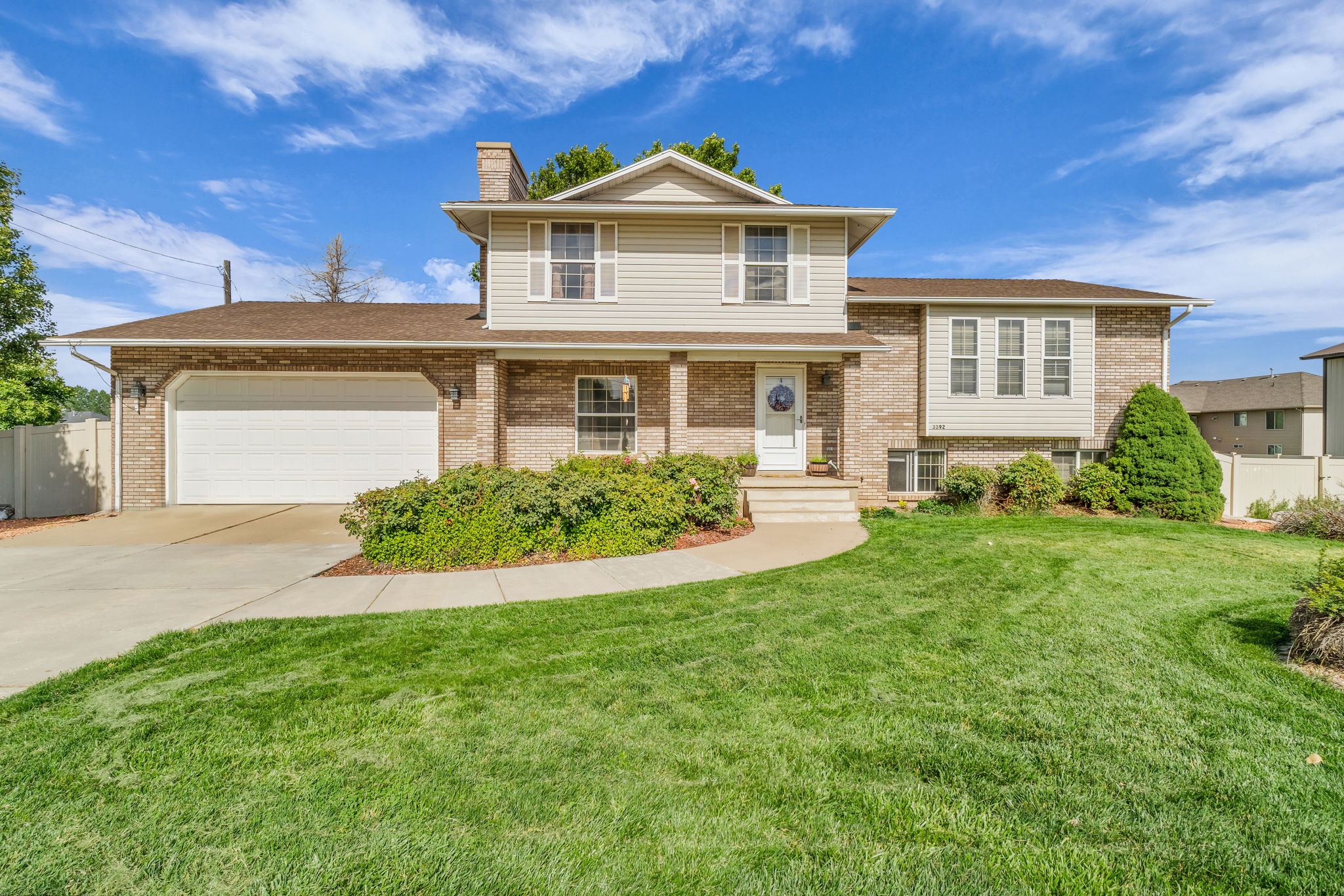 Two-story residence featuring brick and siding exterior, an attached two-car garage, and a concrete driveway