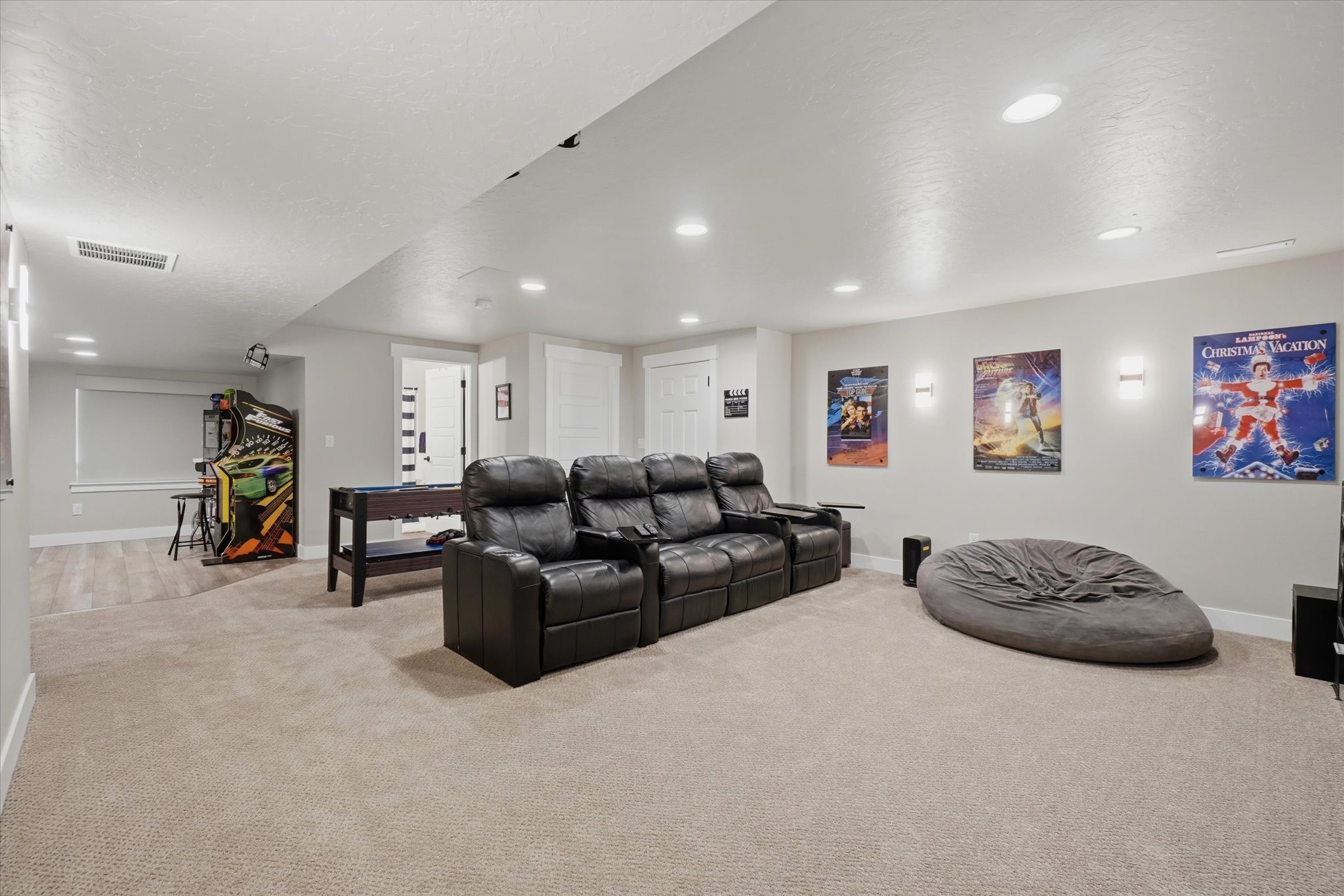 Spacious recreation room featuring recessed lighting, light neutral wall paint, and plush carpeting