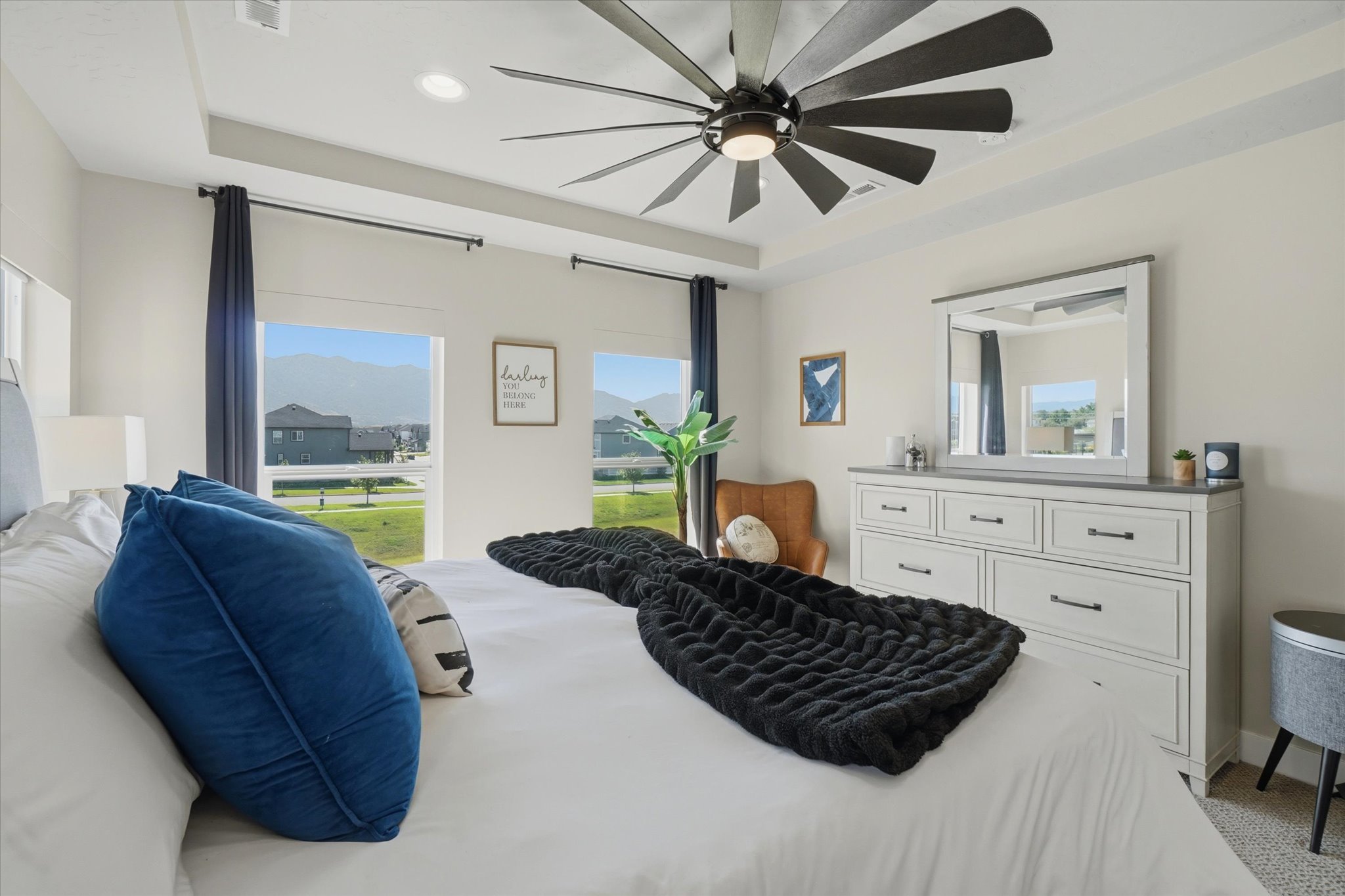 Recessed lighting and a multi-blade ceiling fan complement the tray ceiling