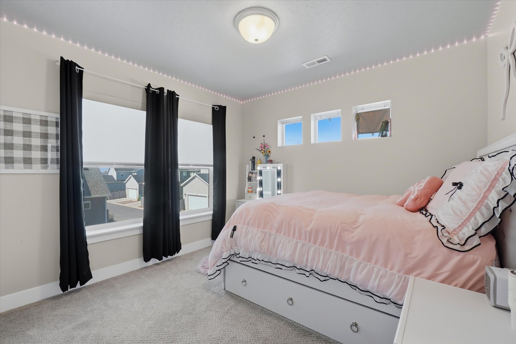 Carpeted room featuring a large multi-pane window, three high-set transom windows, and a flush-mount ceiling light fixture