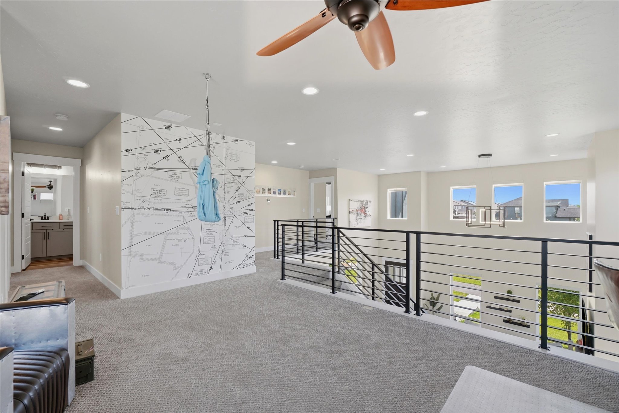 Expansive loft area featuring neutral carpeting and a contemporary ceiling fan with wood-finish blades