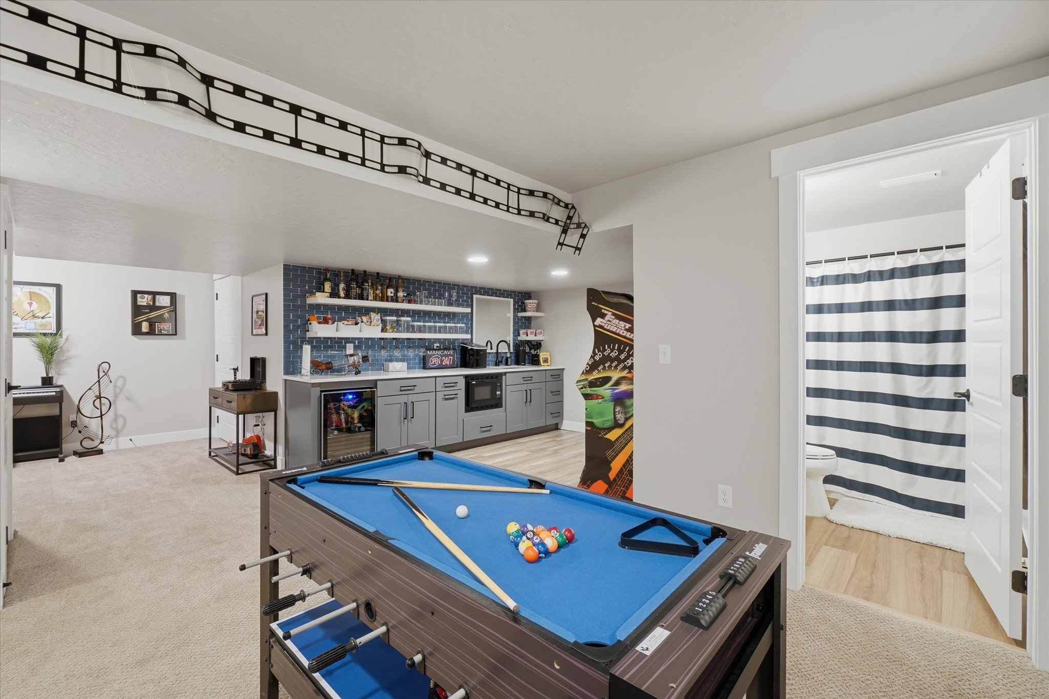 Recreation room featuring a built-in wet bar, wood-finish flooring, and recessed lighting