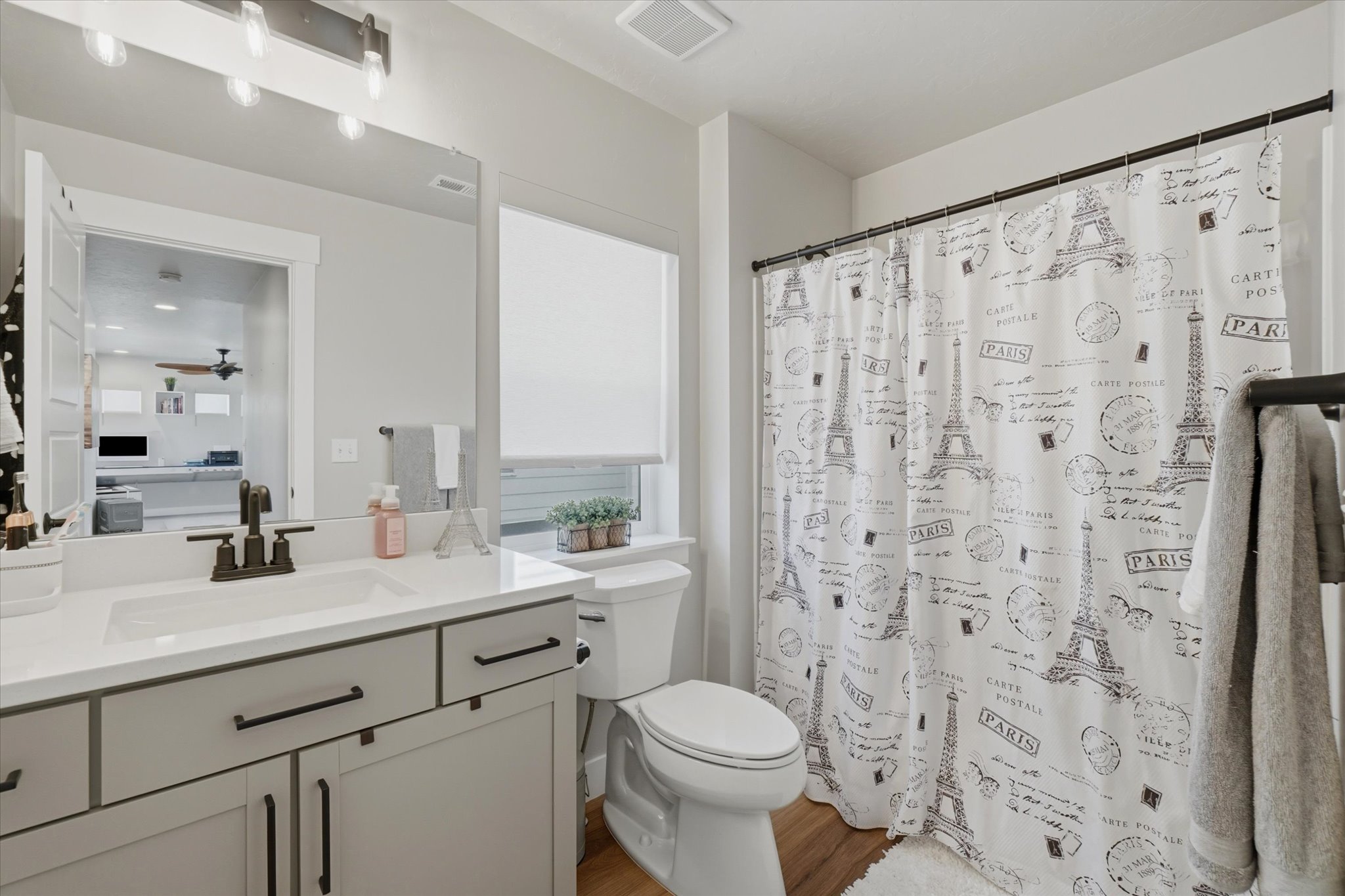 Bathroom featuring a single vanity with a white countertop and dark hardware
