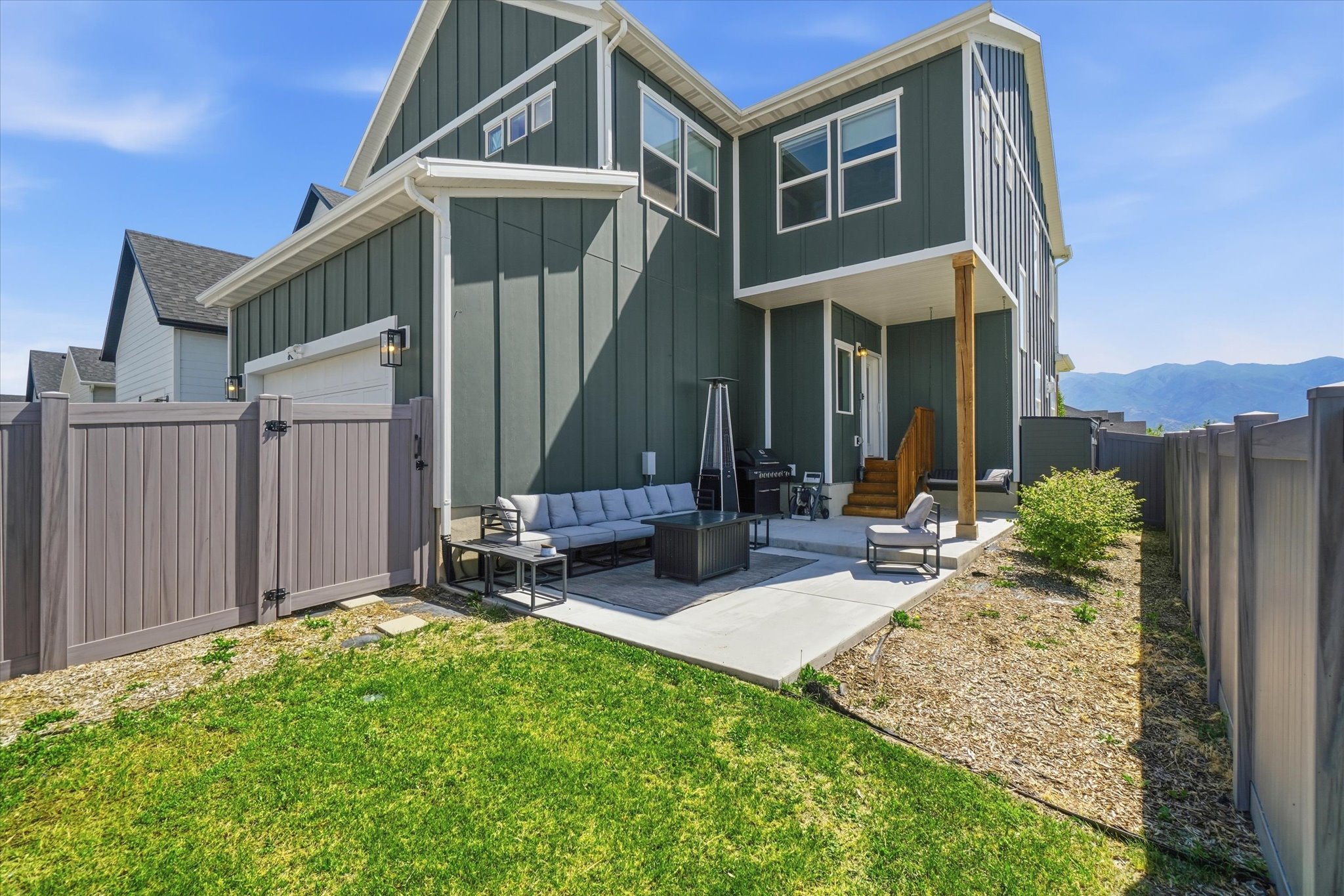 Expansive rear patio featuring concrete surfacing, a privacy fence, and a partially covered outdoor area
