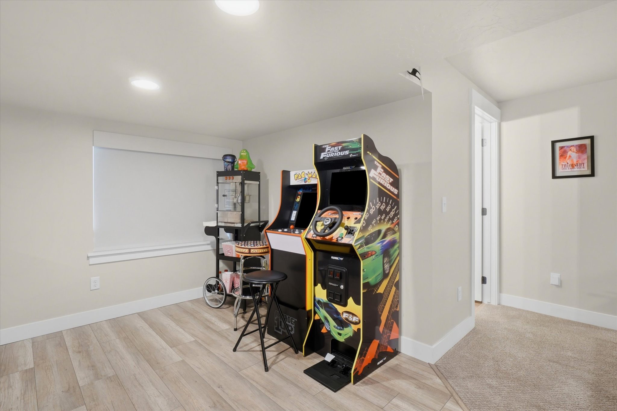 Spacious room featuring light wood-finish flooring, recessed lighting, and a window with white trim