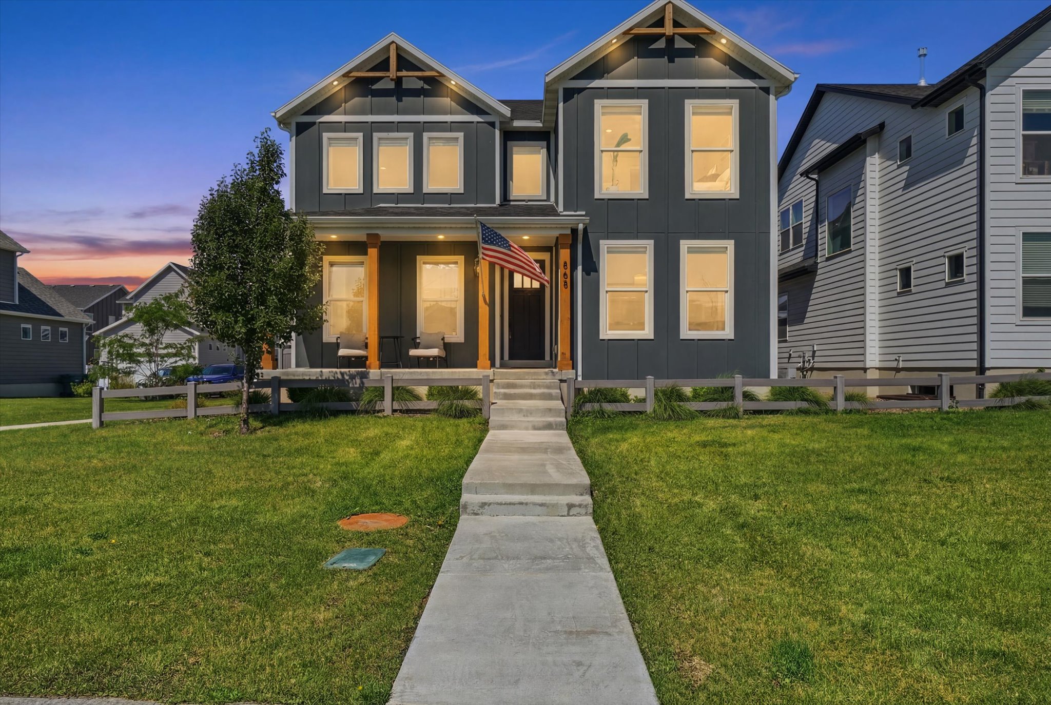 Modern two-story residence featuring dark gray siding and white trim