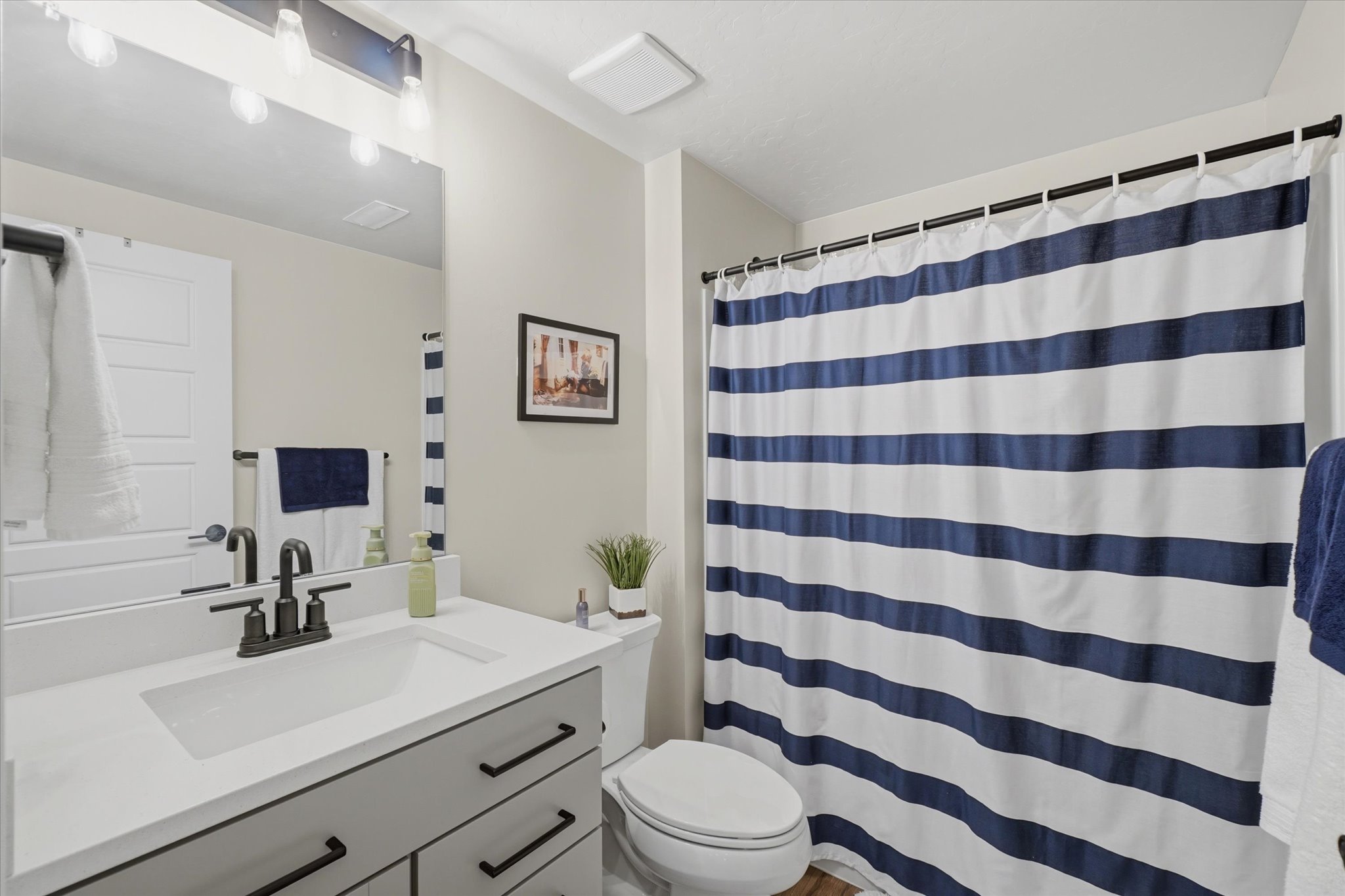 Bathroom featuring a modern vanity with a rectangular undermount sink, a dark bronze widespread faucet, and a large mirror