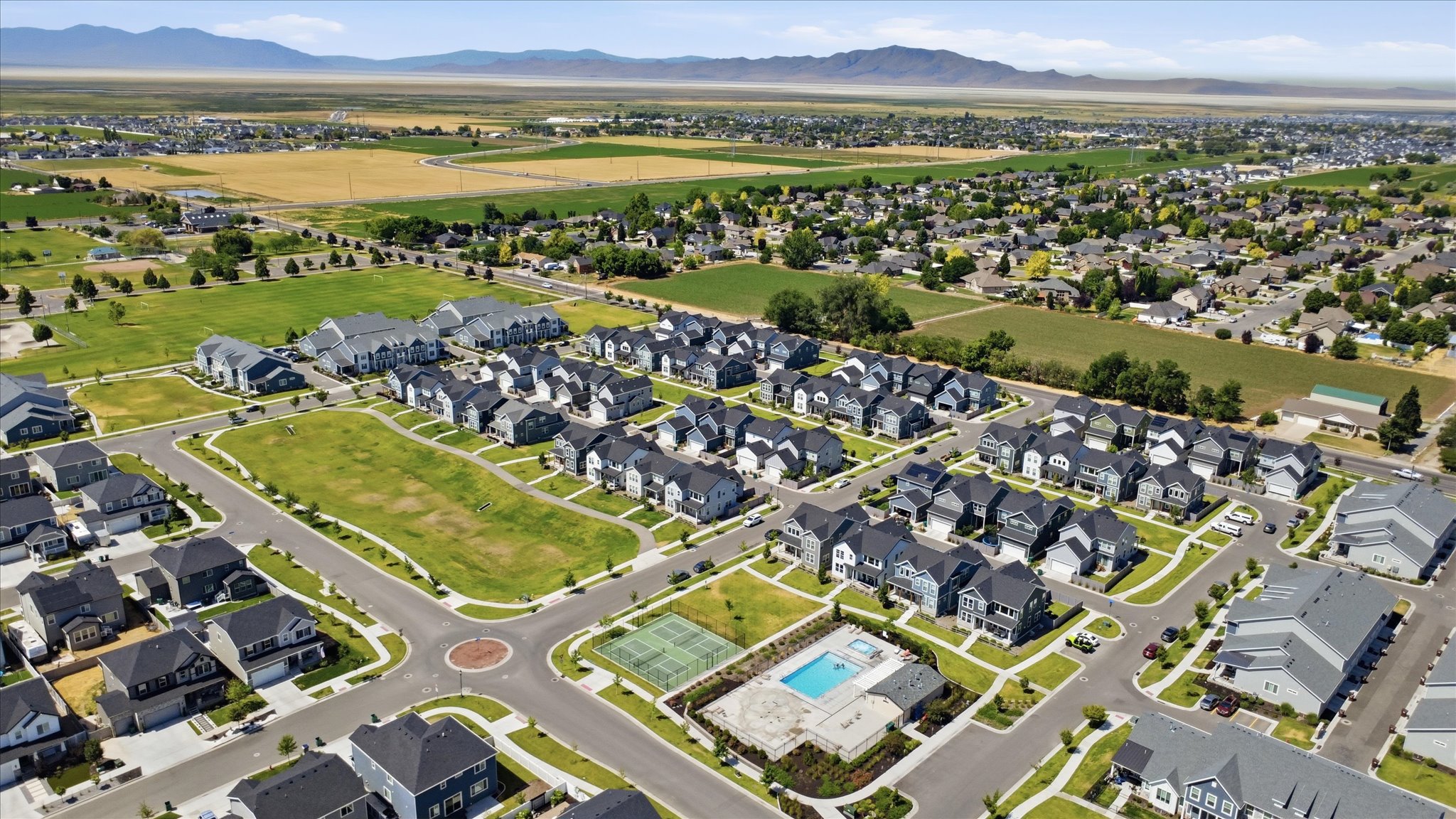 Aerial perspective of a developed residential community featuring single-family homes and townhomes