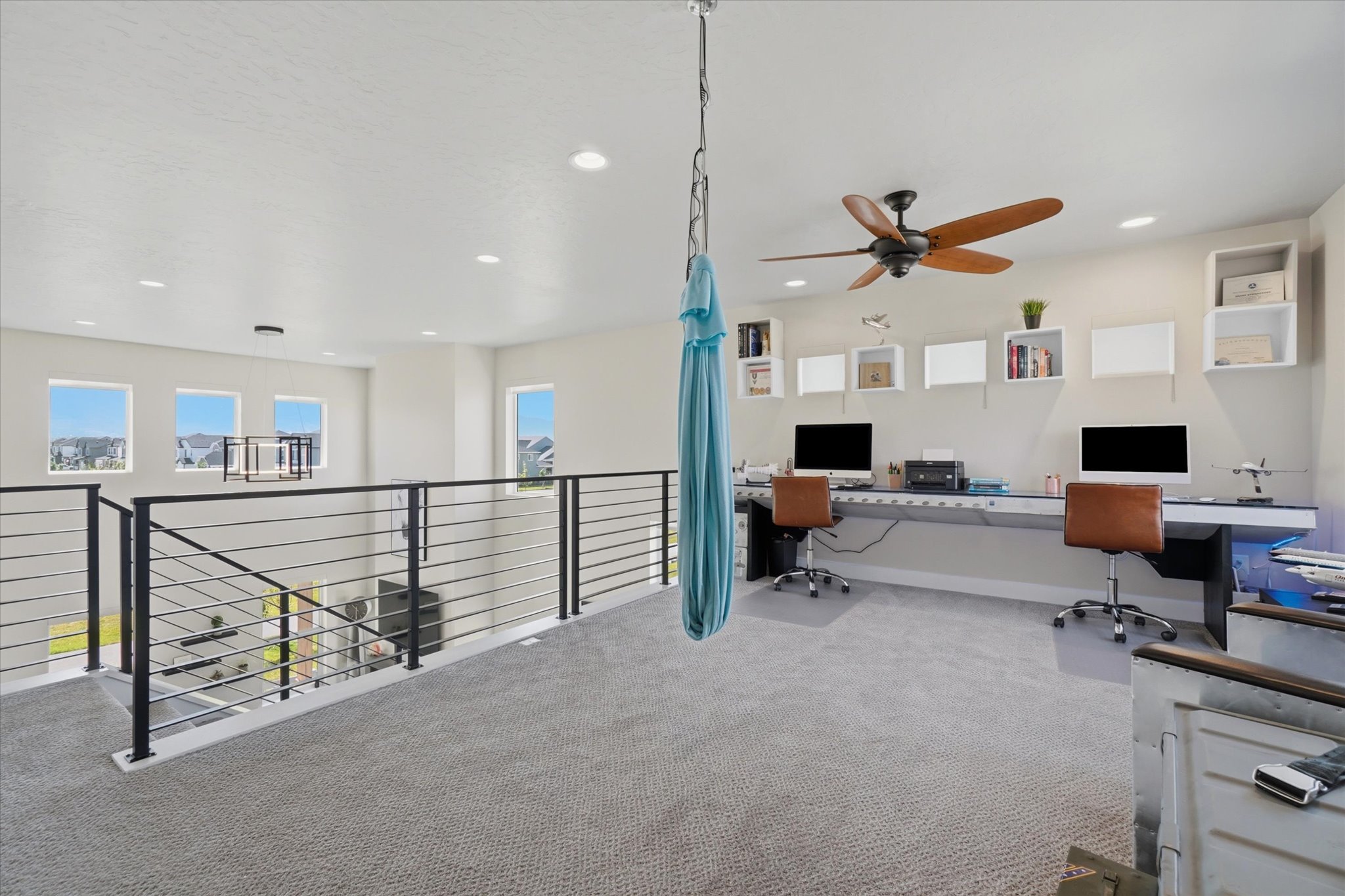 Versatile loft space featuring desk workstation, recessed lighting, and a ceiling fan