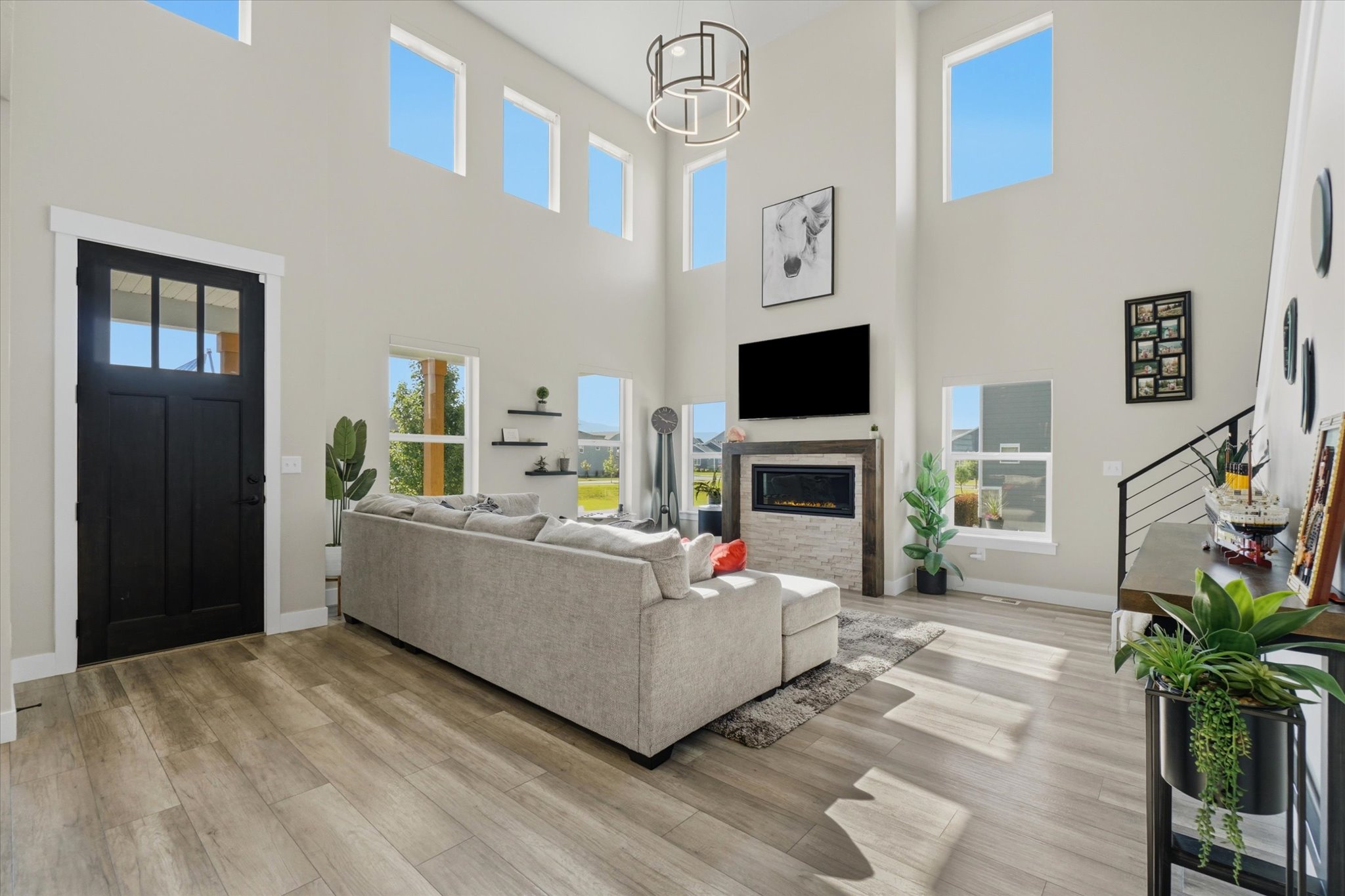 Vaulted living area featuring wood-finish flooring and a contemporary fireplace with a stone surround