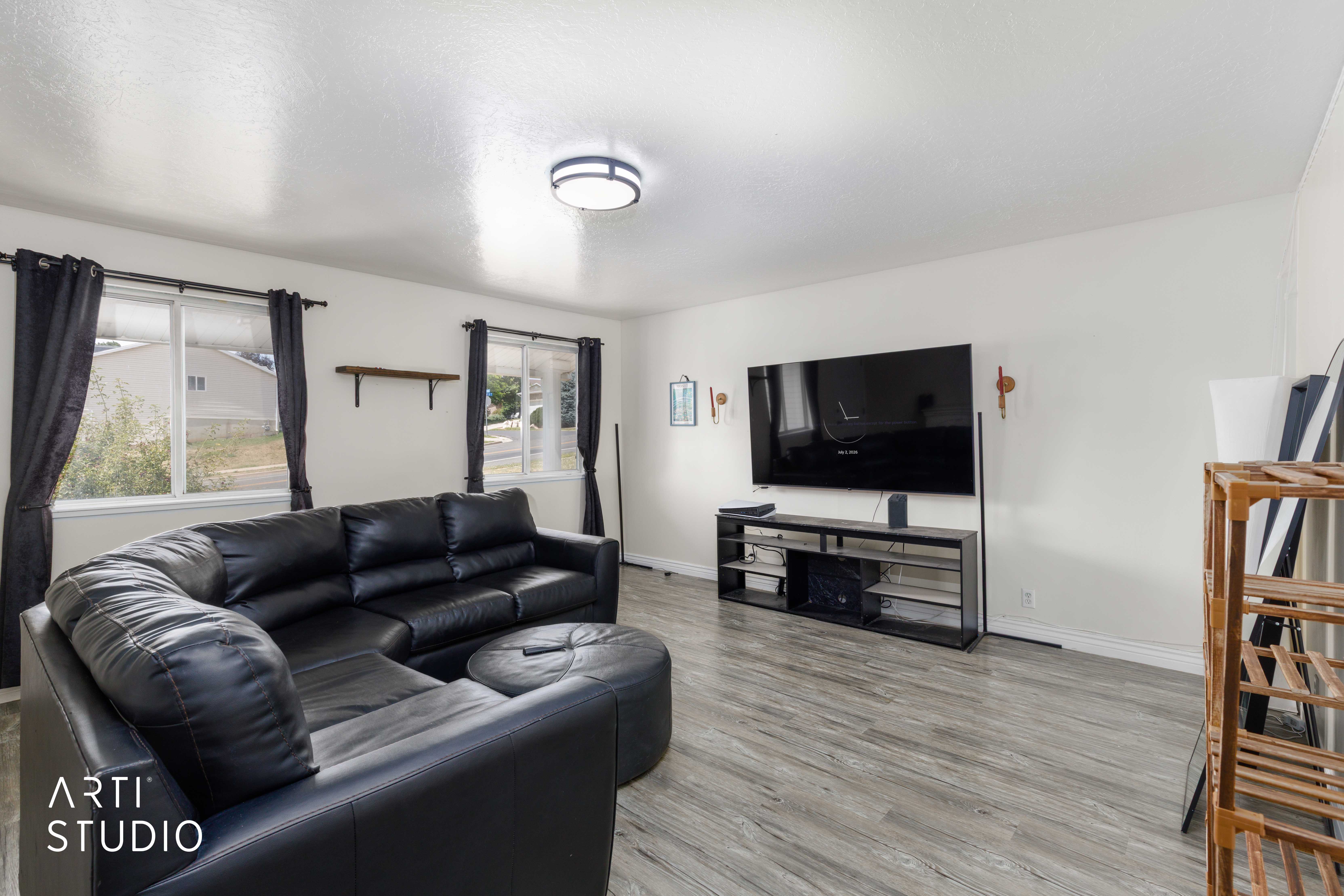Living area featuring light wood-finish flooring and multiple windows