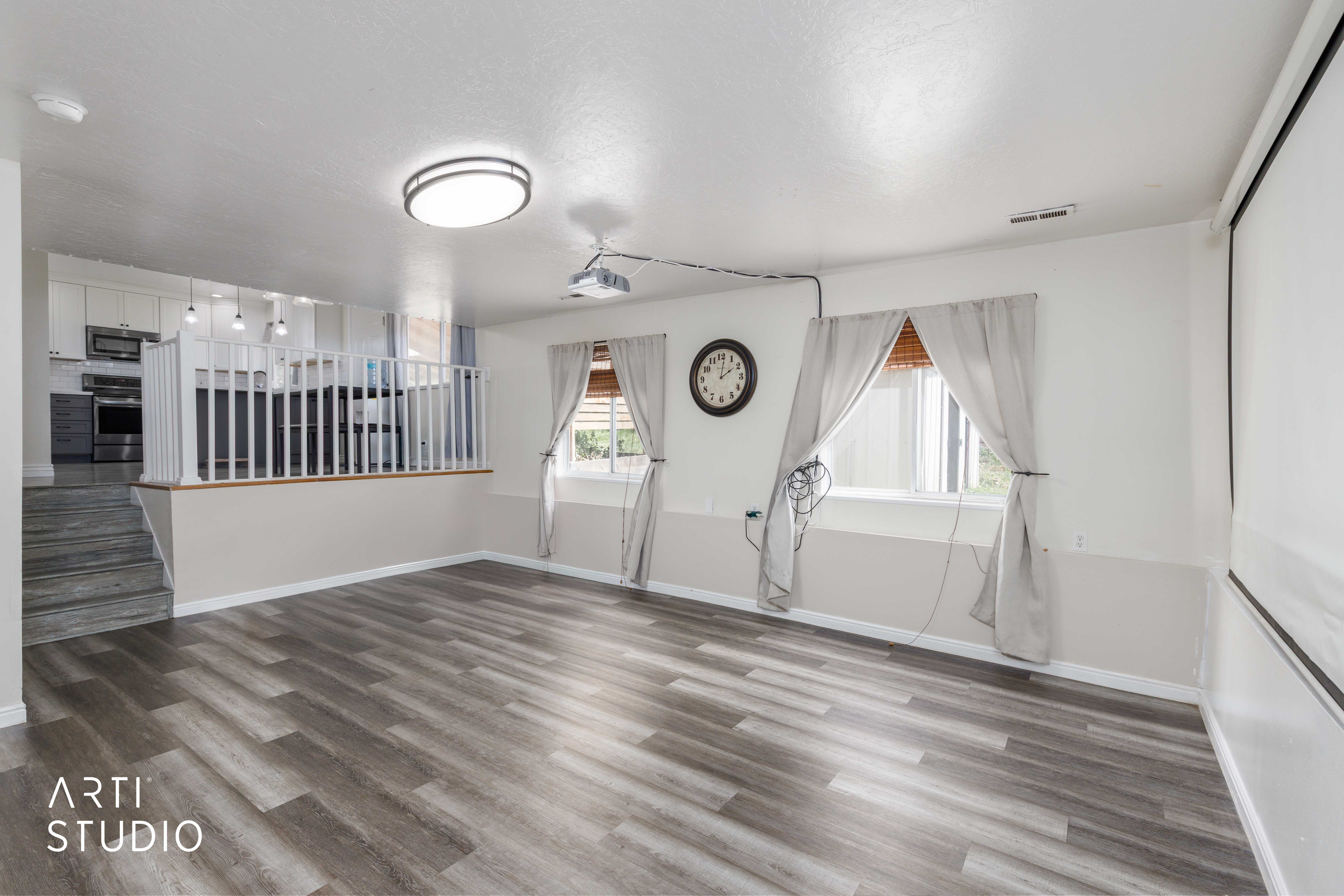 Spacious open-concept living area featuring wood-finish flooring, recessed ceiling light, and direct access to the kitchen