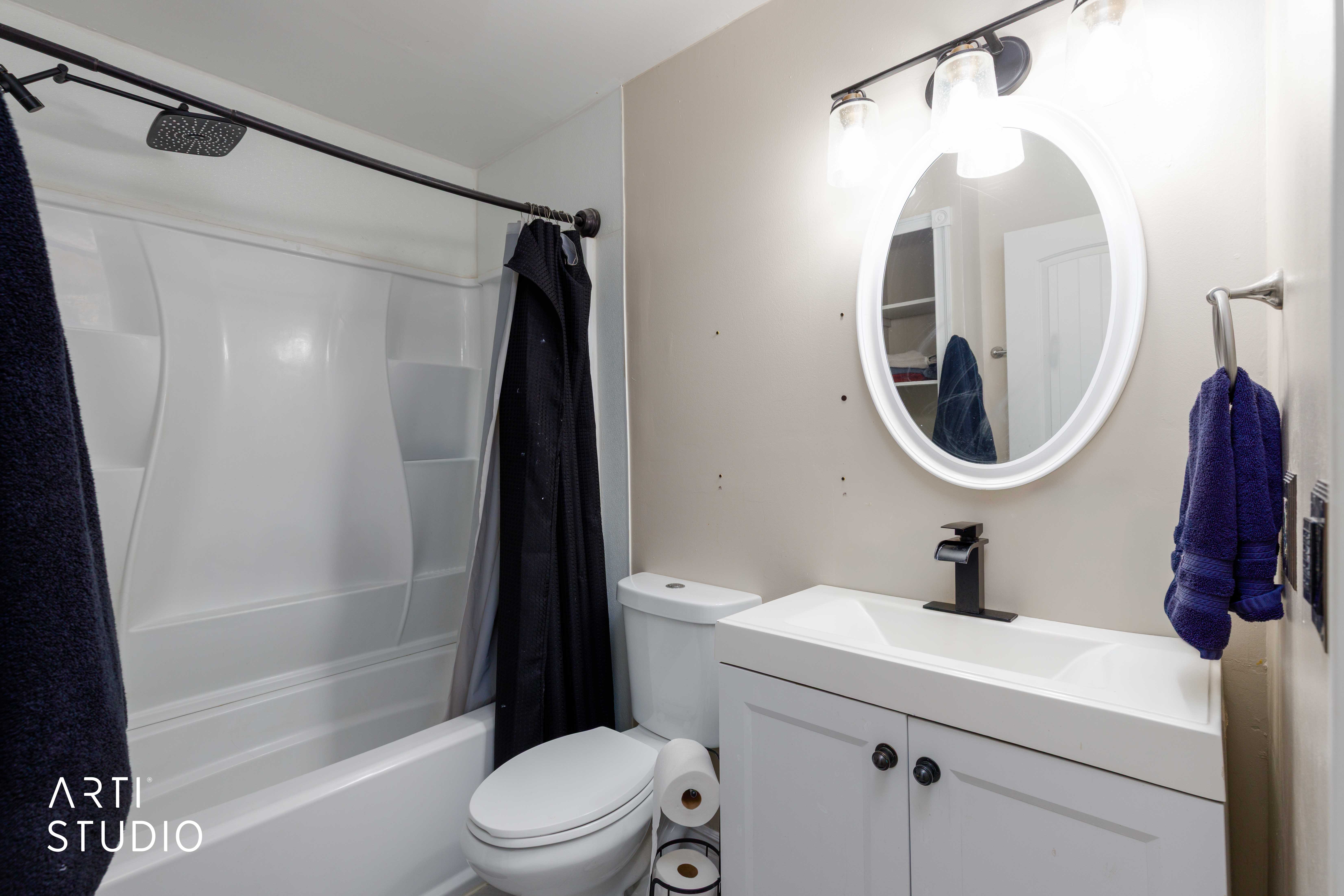 Bathroom featuring a white vanity with cabinet storage, integrated sink, and matte black faucet