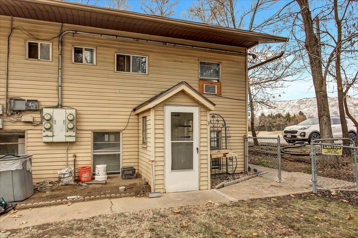 Rear exterior featuring tan siding and multiple windows