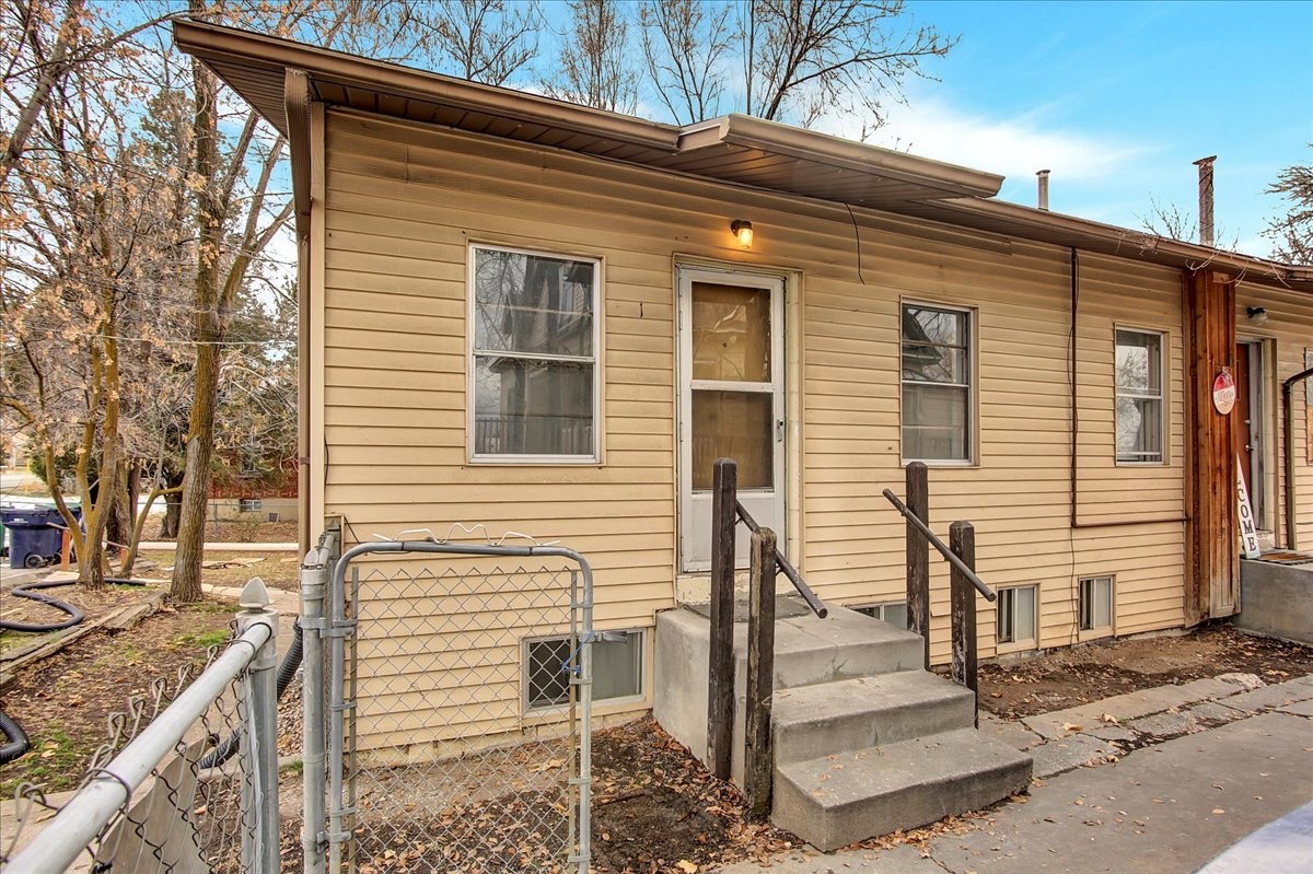 Exterior with horizontal siding, multiple windows, and a concrete staircase leading to an entry door
