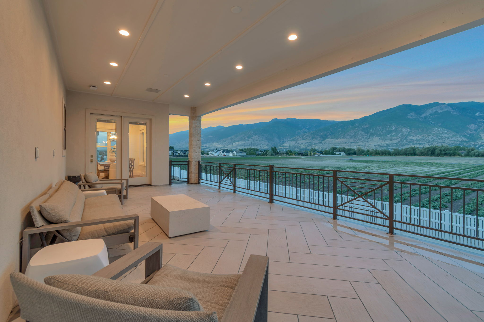 Spacious outdoor living area with a mountain backdrop, featuring  epoxy coating system and custom iron rail