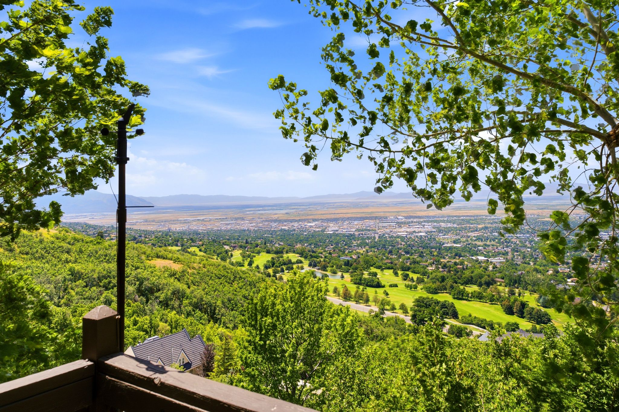Views featuring distant city elements, verdant hillsides, and a bright blue sky