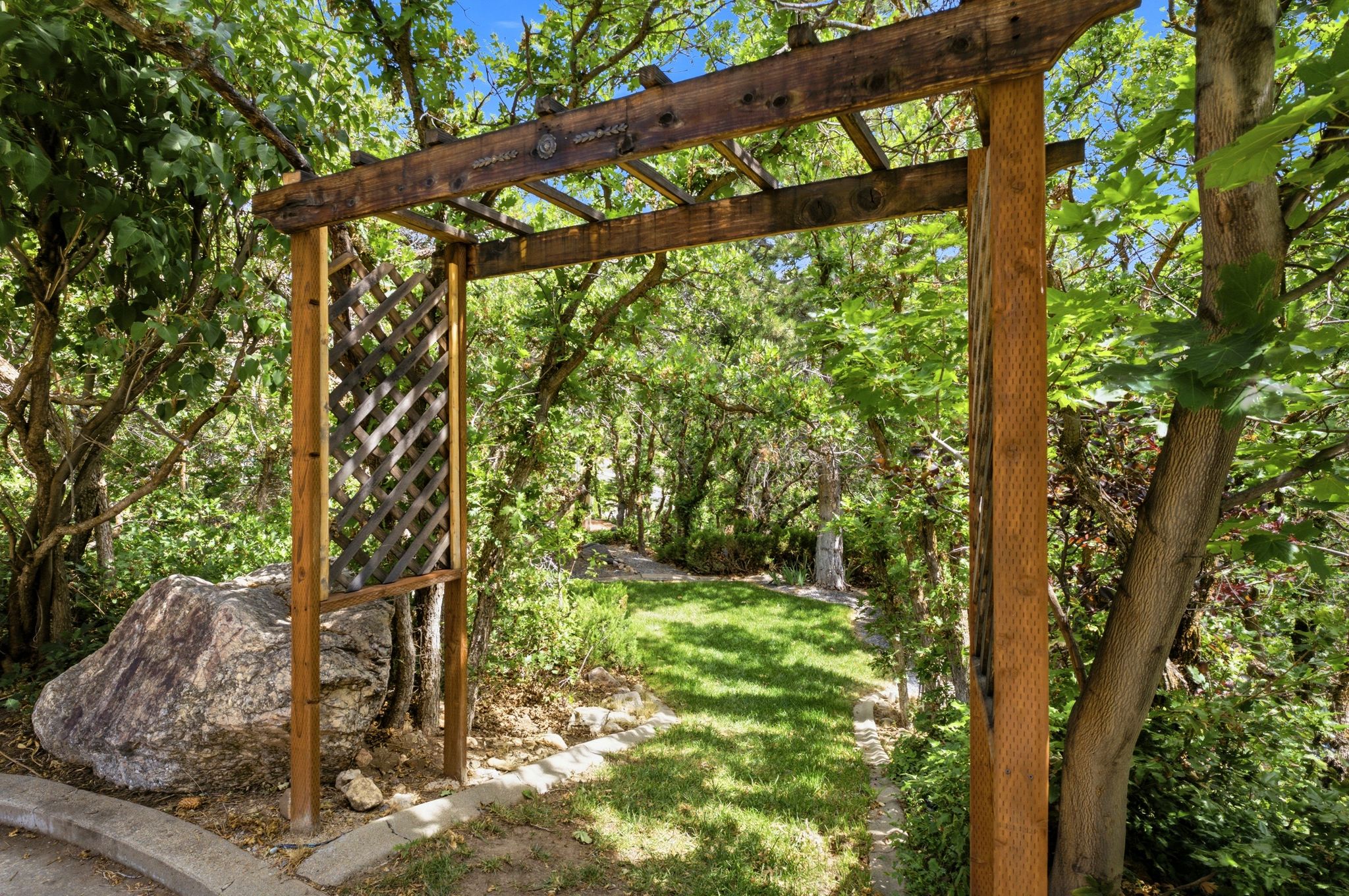 Wood pergola entry featuring a lattice side panel and natural wood tones