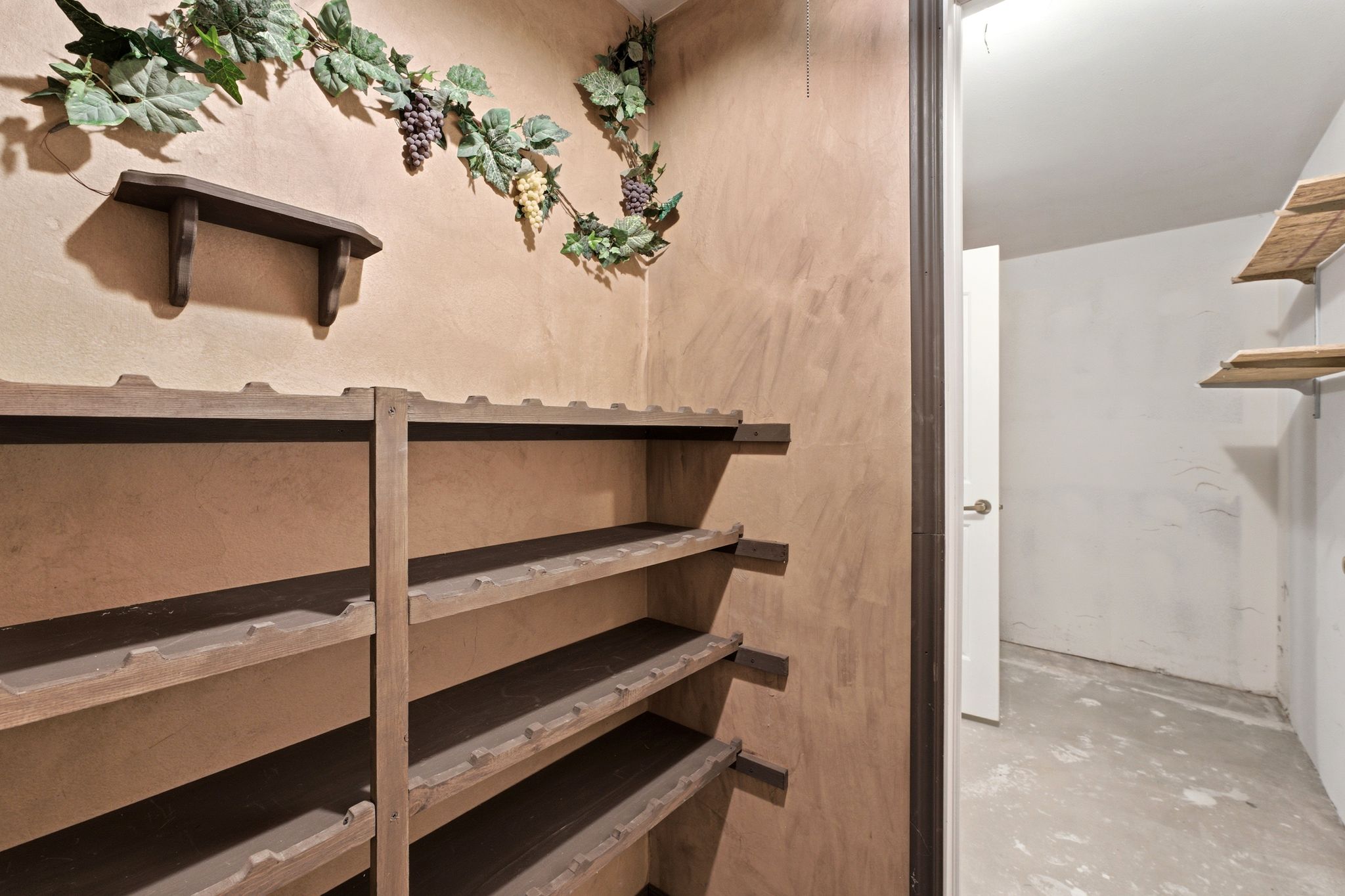 Custom wine racks with multiple tiers and an integrated wall shelf