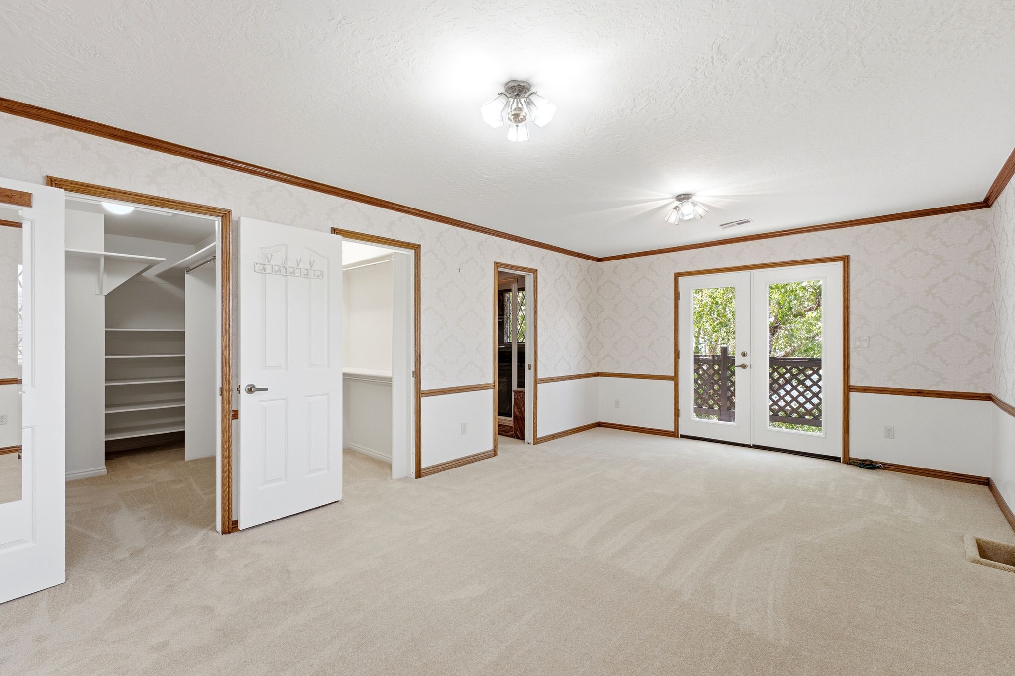 Primary suite sitting area - view of double walk-in closets, bathroom and door to upper deck