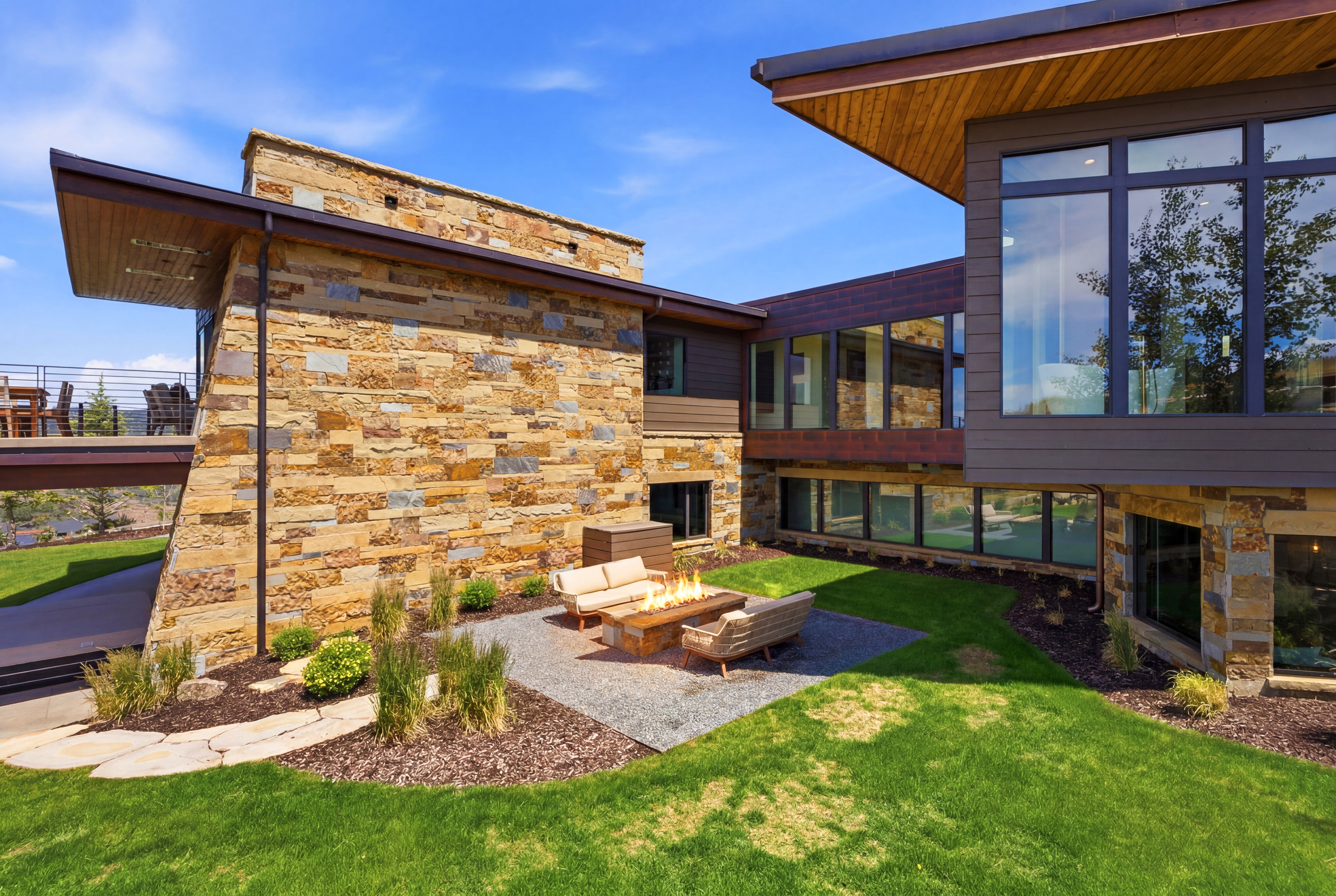 Exterior featuring extensive stone masonry, large multi-pane windows, and a wood-paneled soffit