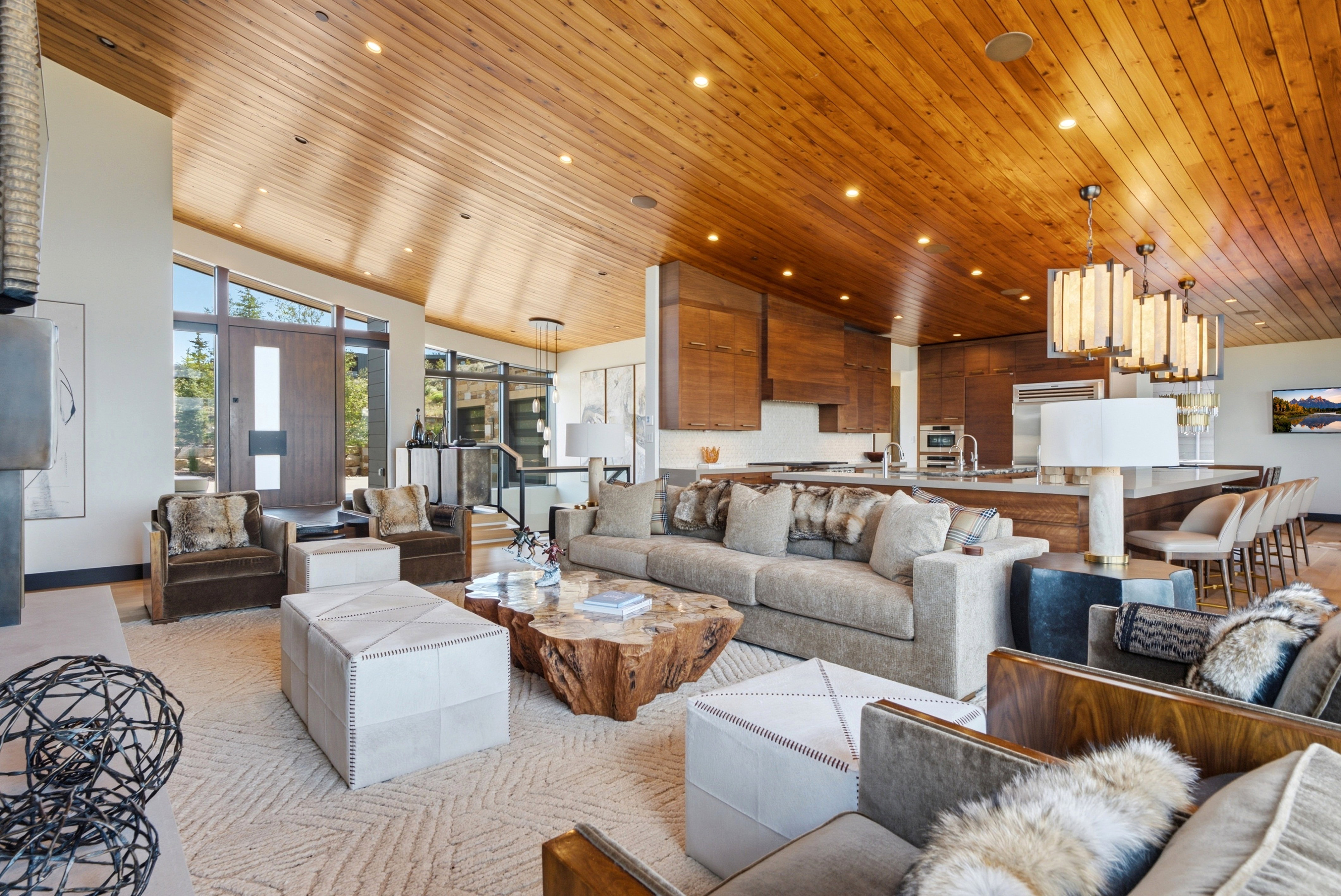 Spacious living area featuring a vaulted wood-paneled ceiling with recessed lighting