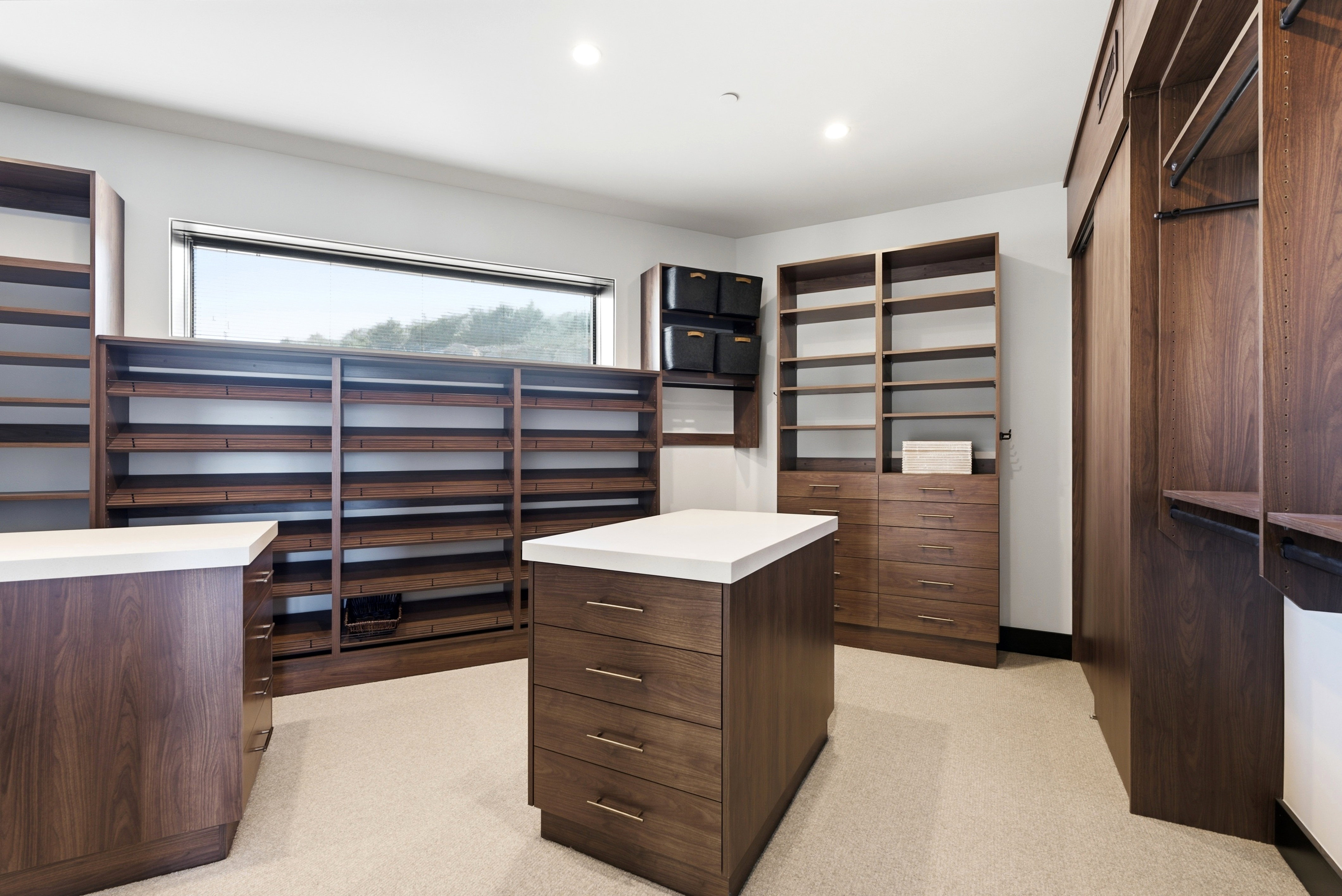 Custom closet system featuring rich wood-finish cabinetry, extensive shelving, and multiple drawers