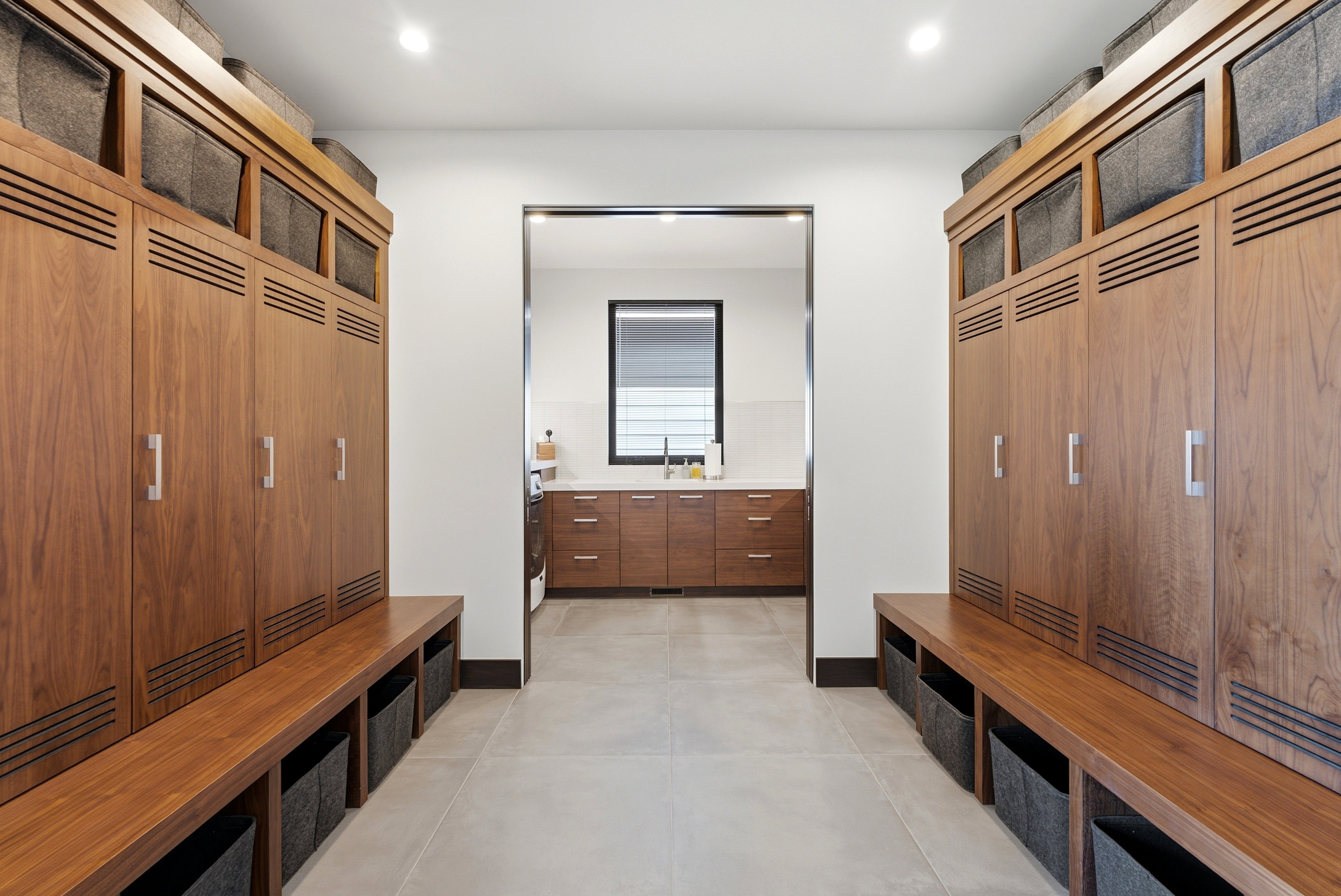 Hallway with built-in wood cabinetry, integrated bench seating, and light-toned floor tile