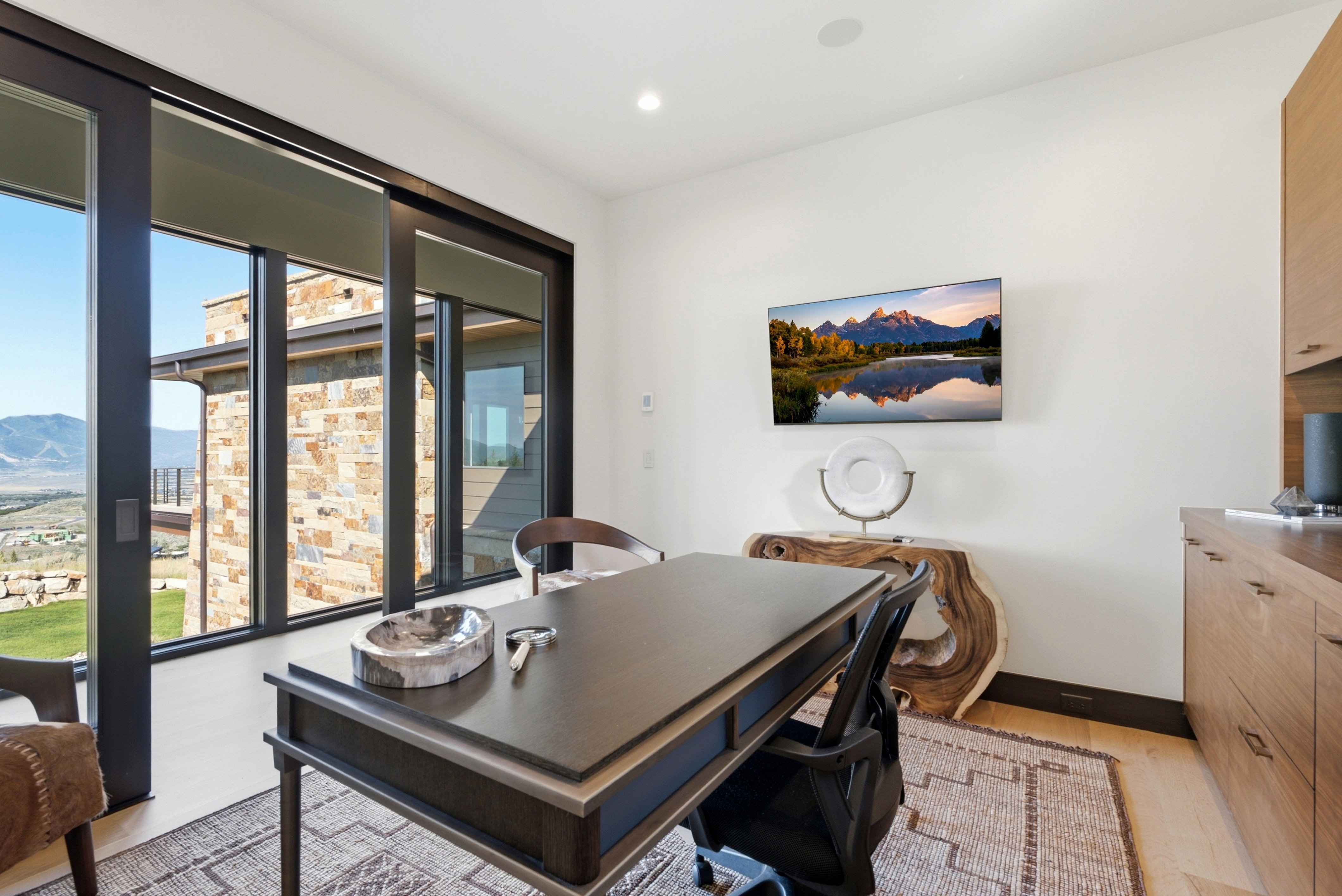 Office space featuring expansive sliding glass doors, built-in wood cabinetry, and light wood-finish flooring