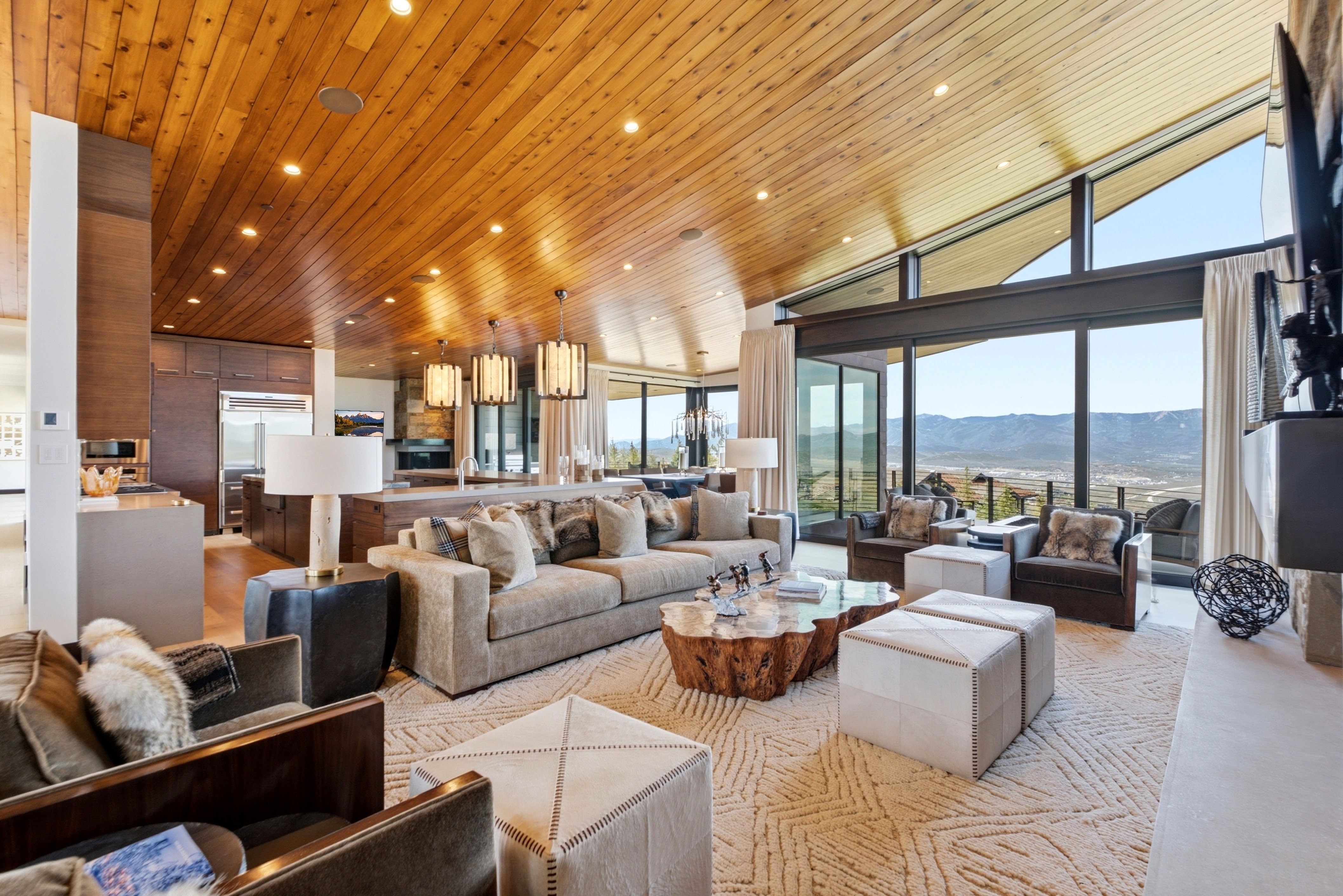 Vaulted wood-finish ceilings with recessed lighting, large format sliding glass doors, built-in cabinetry, and integrated kitchen appliances