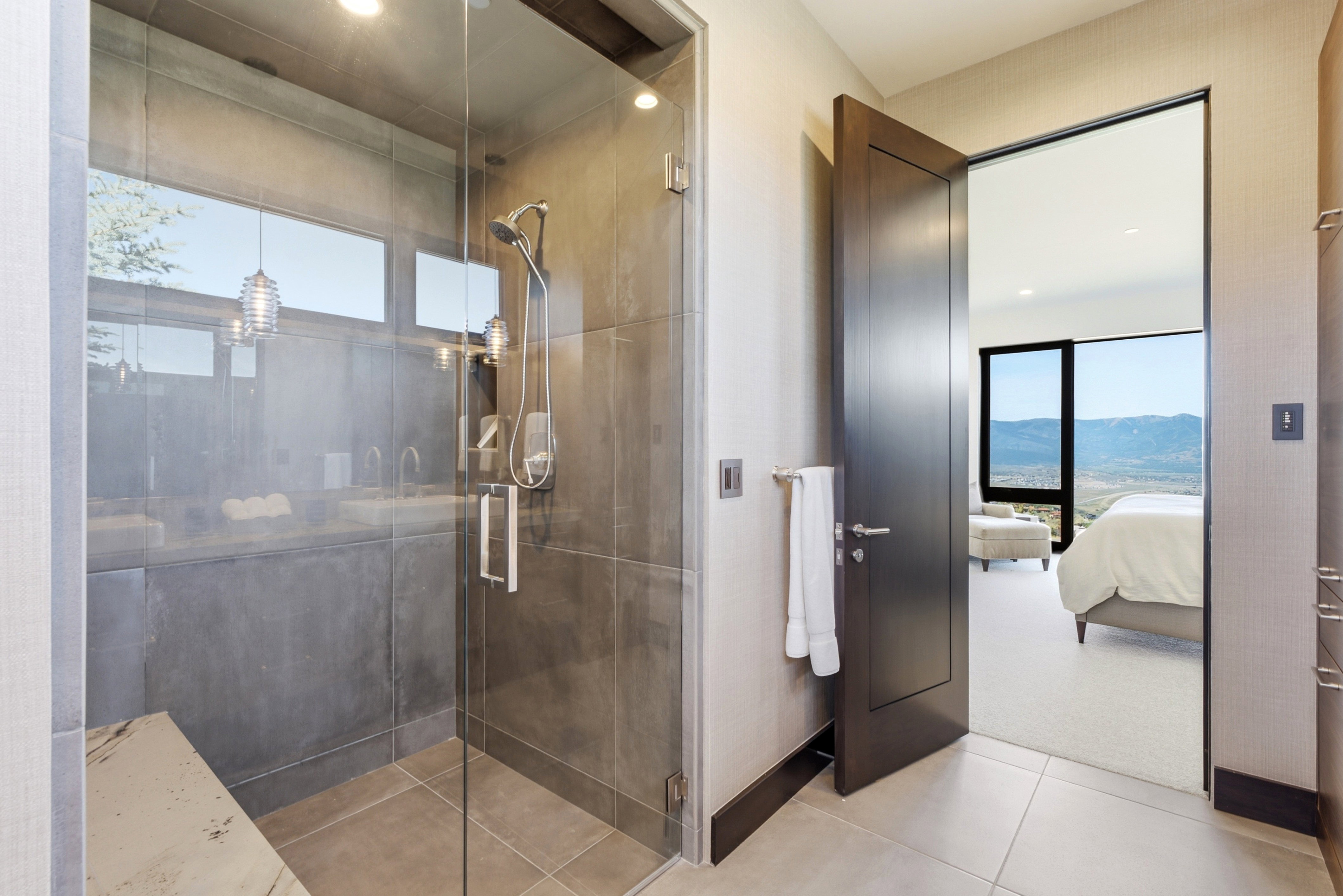 Spacious walk-in shower featuring a glass enclosure, a built-in bench, and a rainfall showerhead