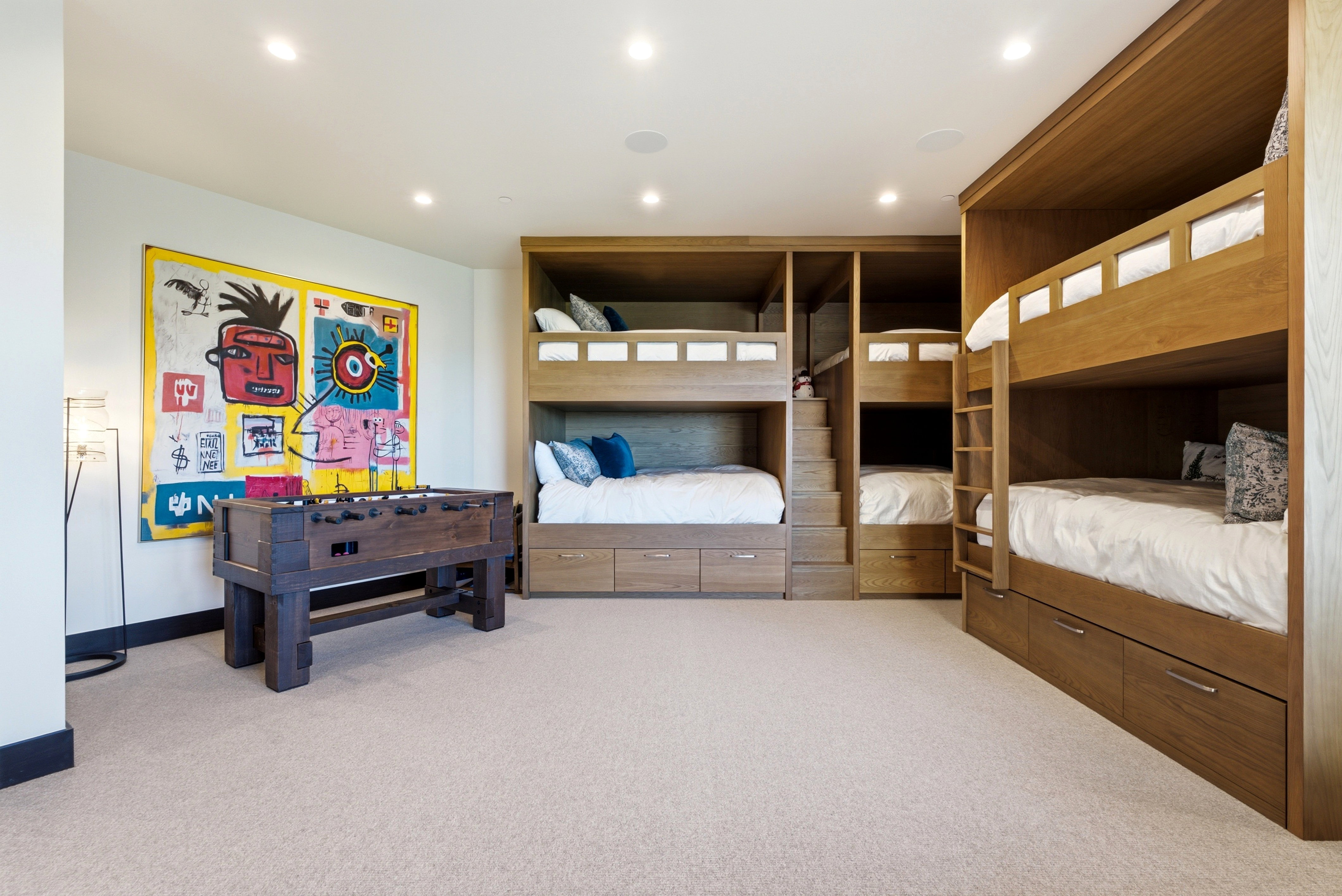Custom built-in bunk beds featuring integrated storage drawers and access stairs