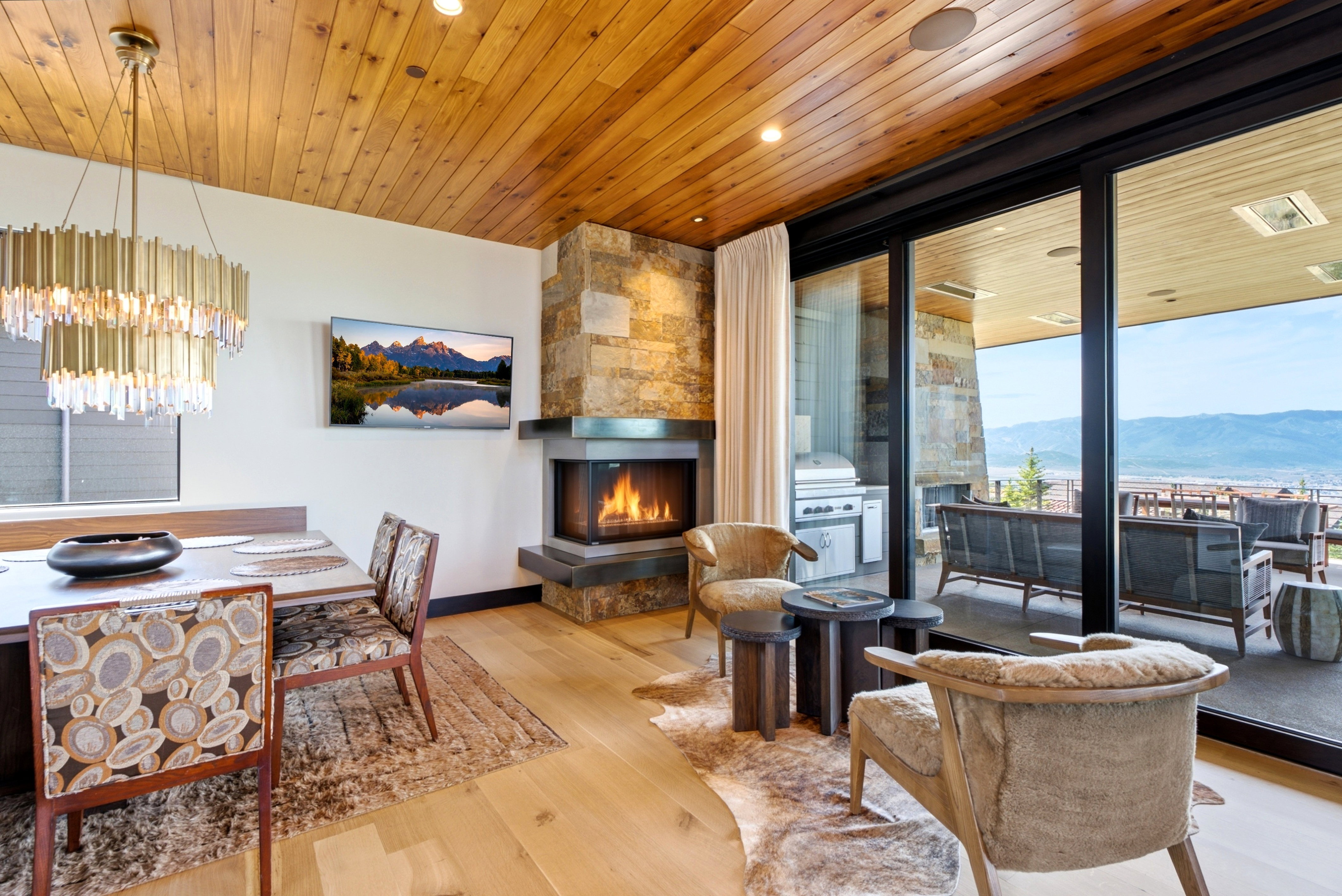 Open-concept living space with wood-finish flooring and a natural wood plank ceiling