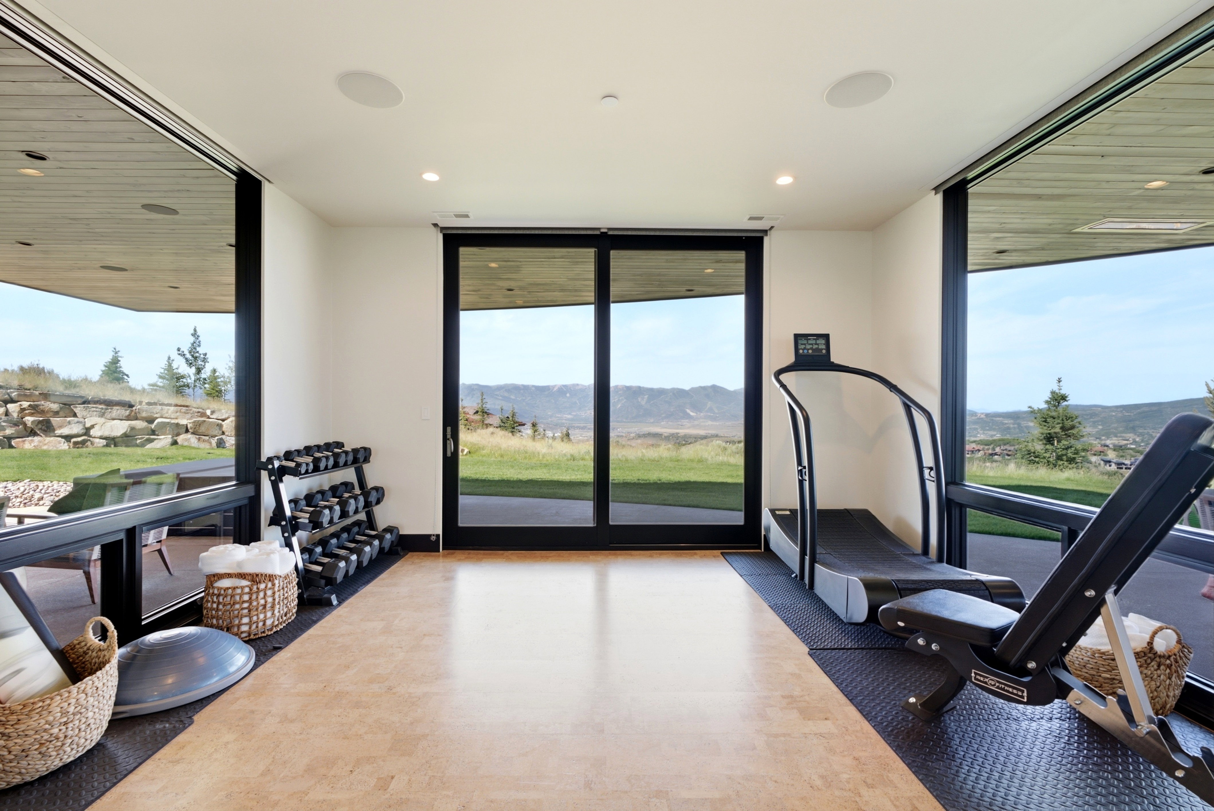 Dedicated fitness space featuring wood-finish flooring, floor-to-ceiling windows, and recessed lighting