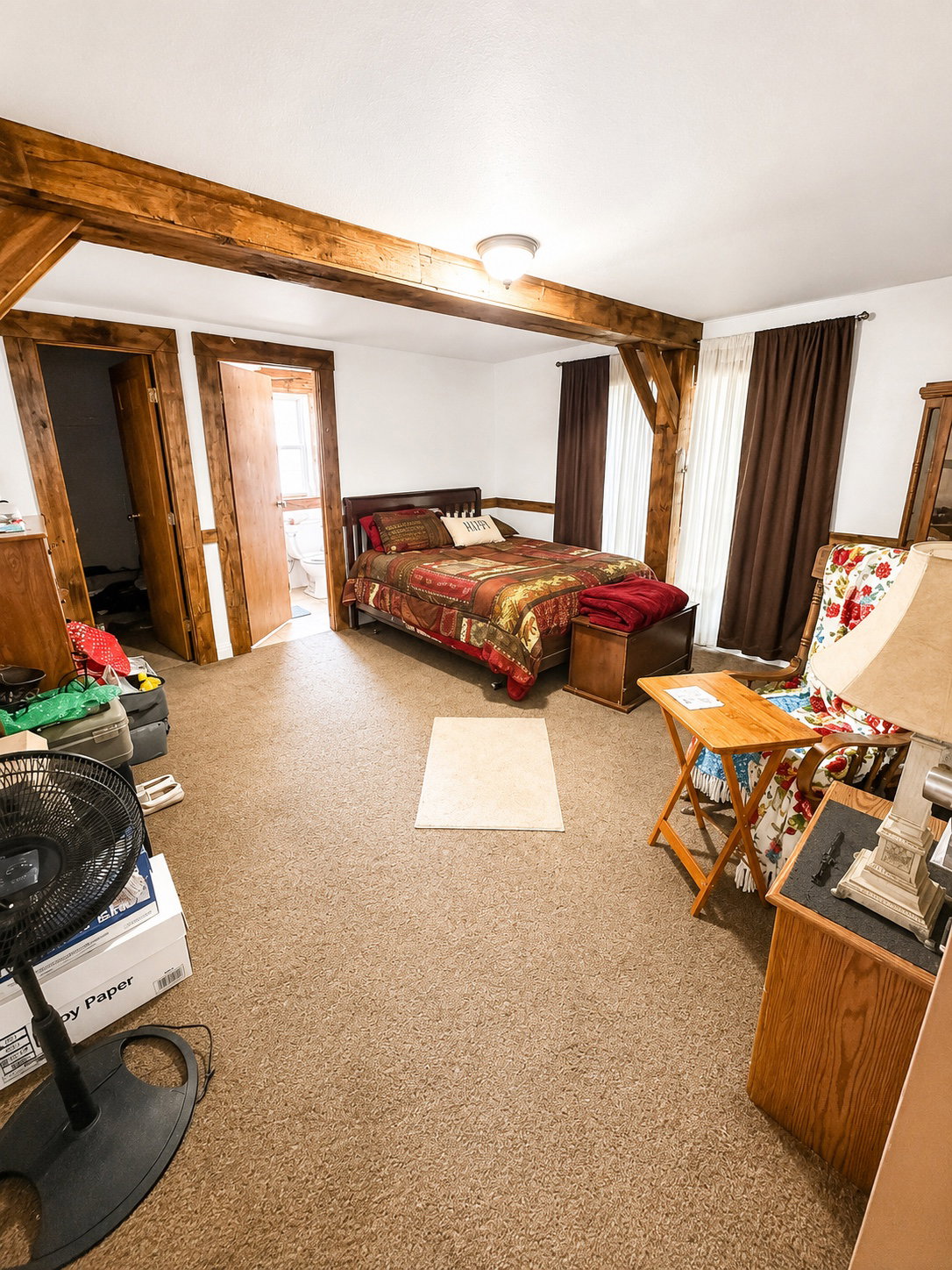 Room featuring exposed wooden beams and door frames
