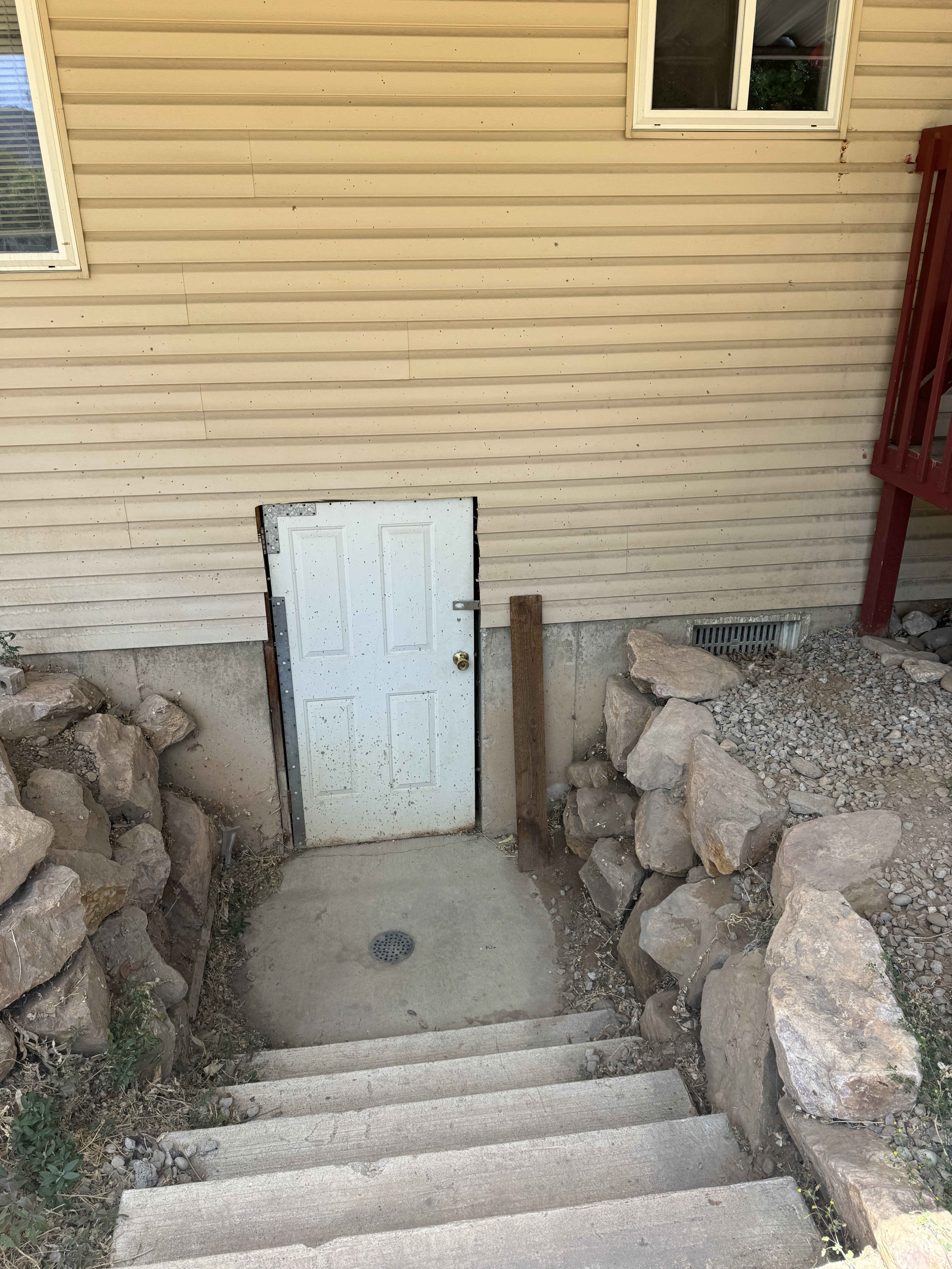 Concrete stairs providing access to a lower-level entry door
