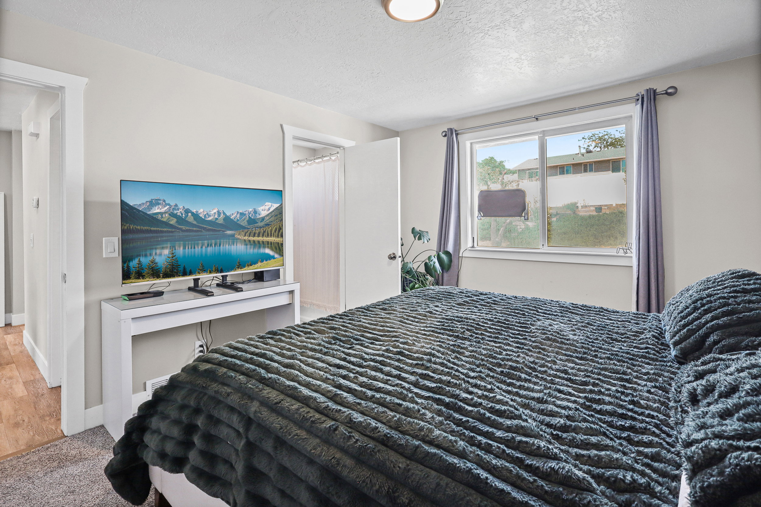 Bedroom featuring light gray wall paint and a textured ceiling
