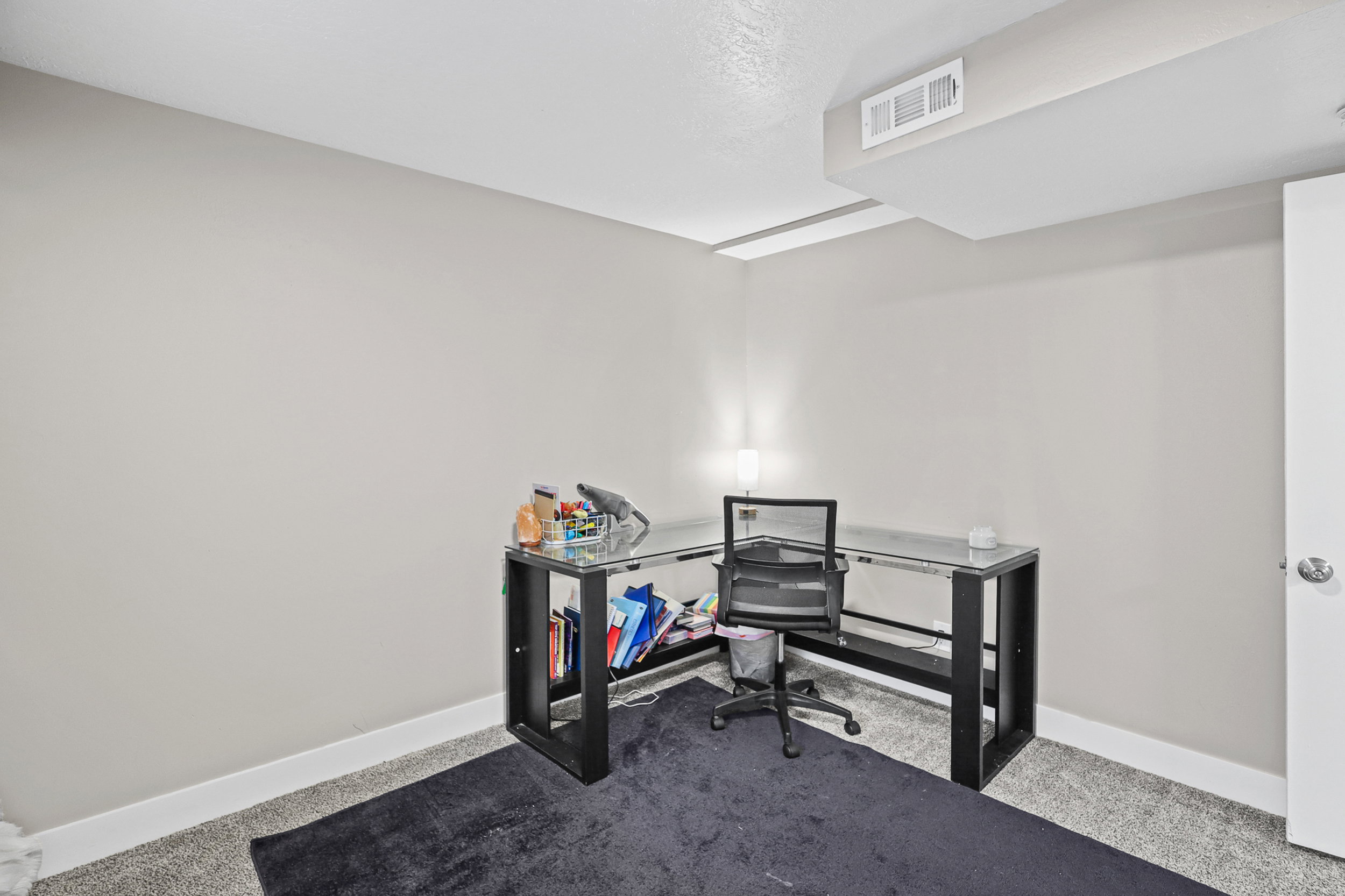 Neutral wall color, wall-to-wall carpeting, white baseboards, and a white ceiling with a built-in vent