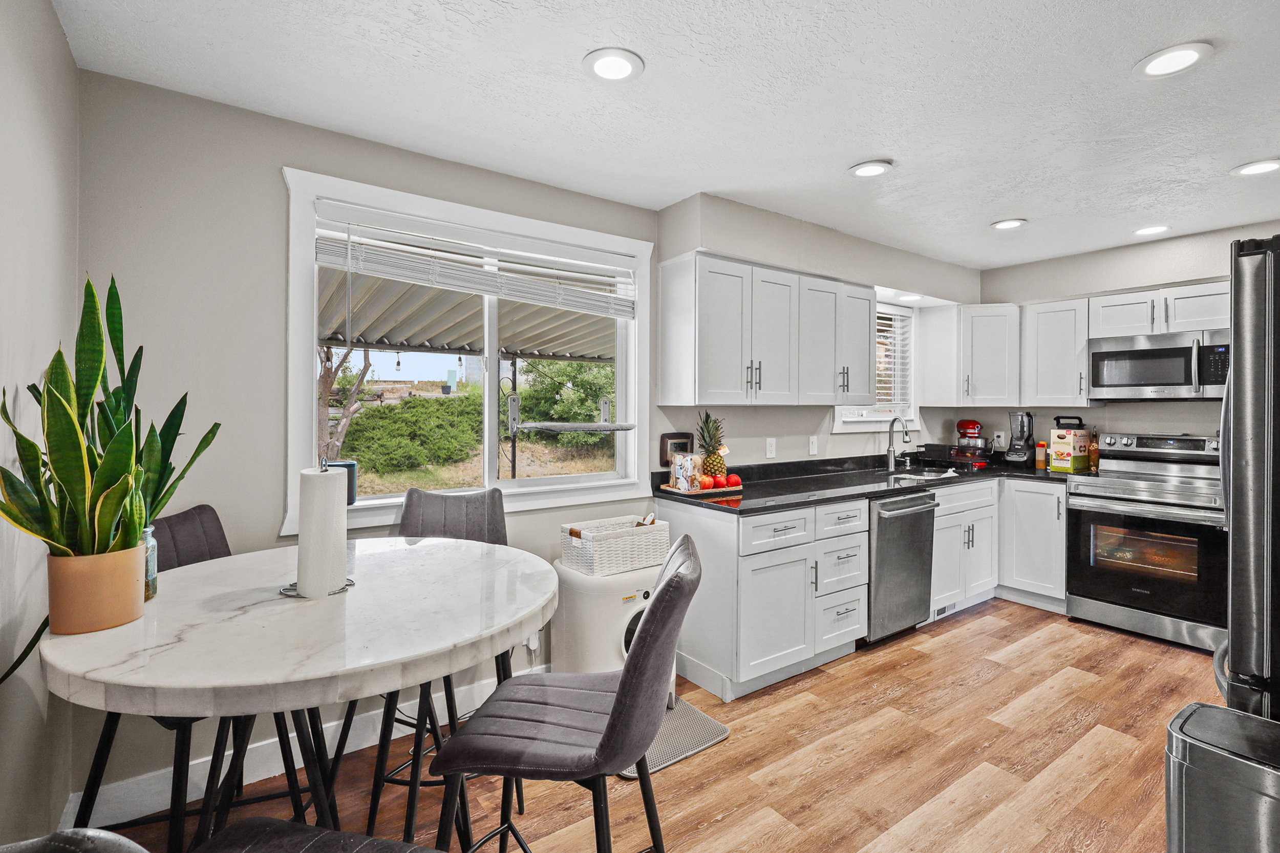 Contemporary kitchen featuring white cabinetry, dark countertops, and stainless steel appliances