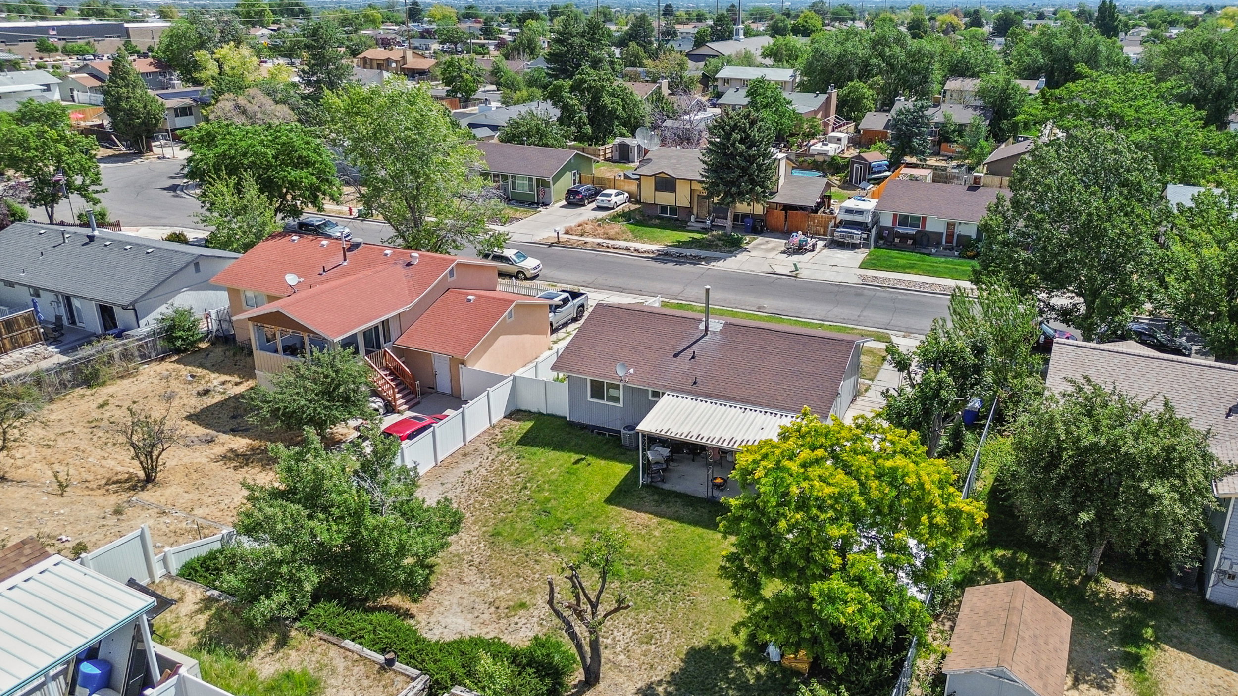 Aerial overview showcasing multiple properties with residential structures and established trees