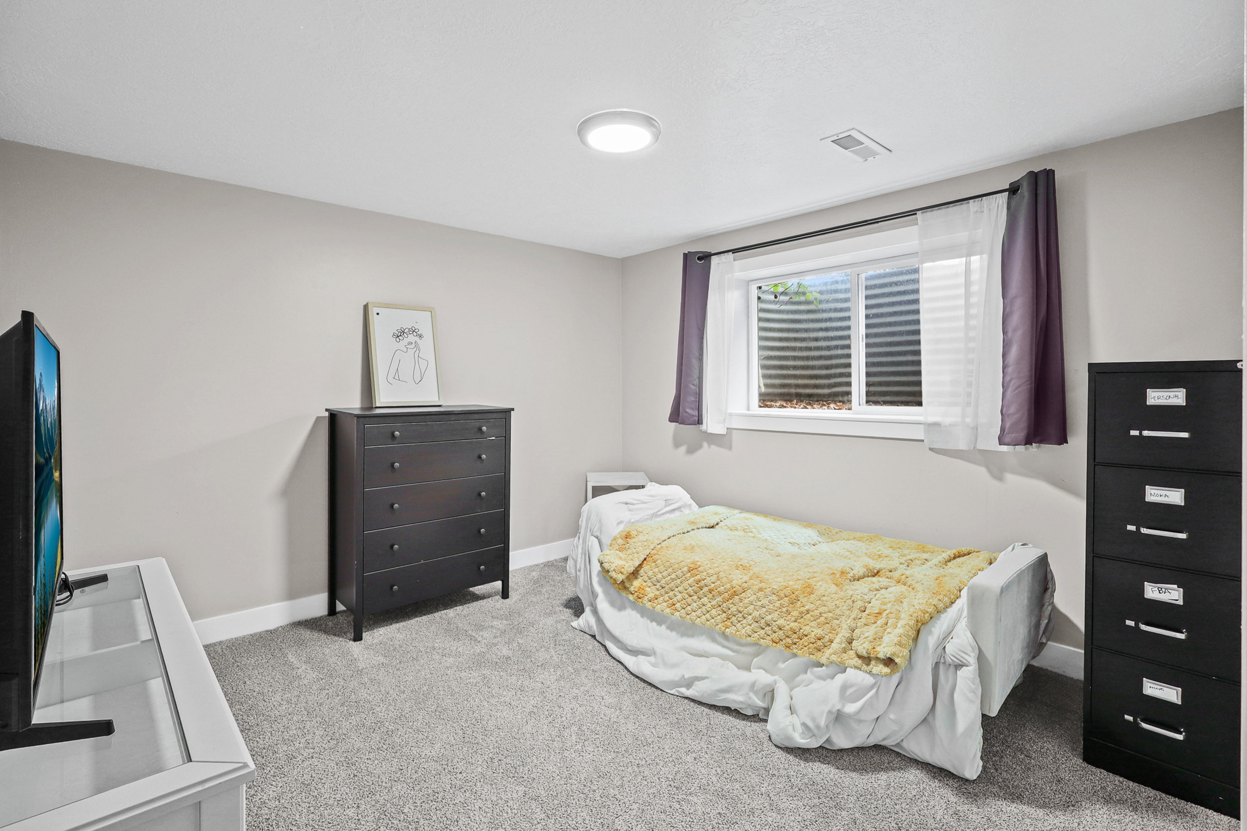 Carpeted room with a window, white baseboards, and a flush-mount ceiling light