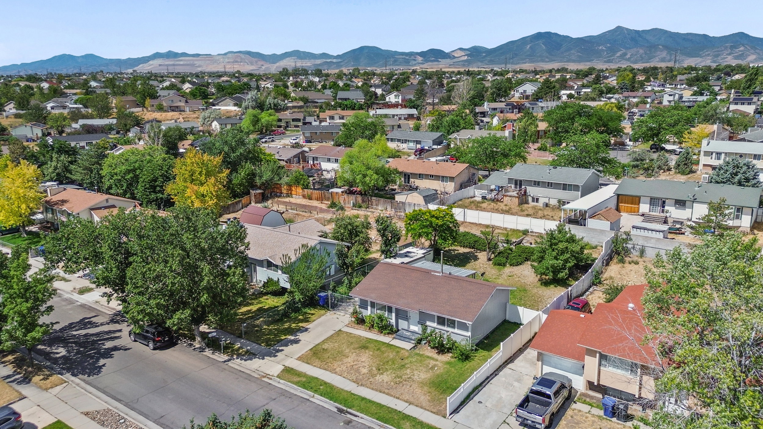 Residential neighborhood with mature trees and mountain backdrop