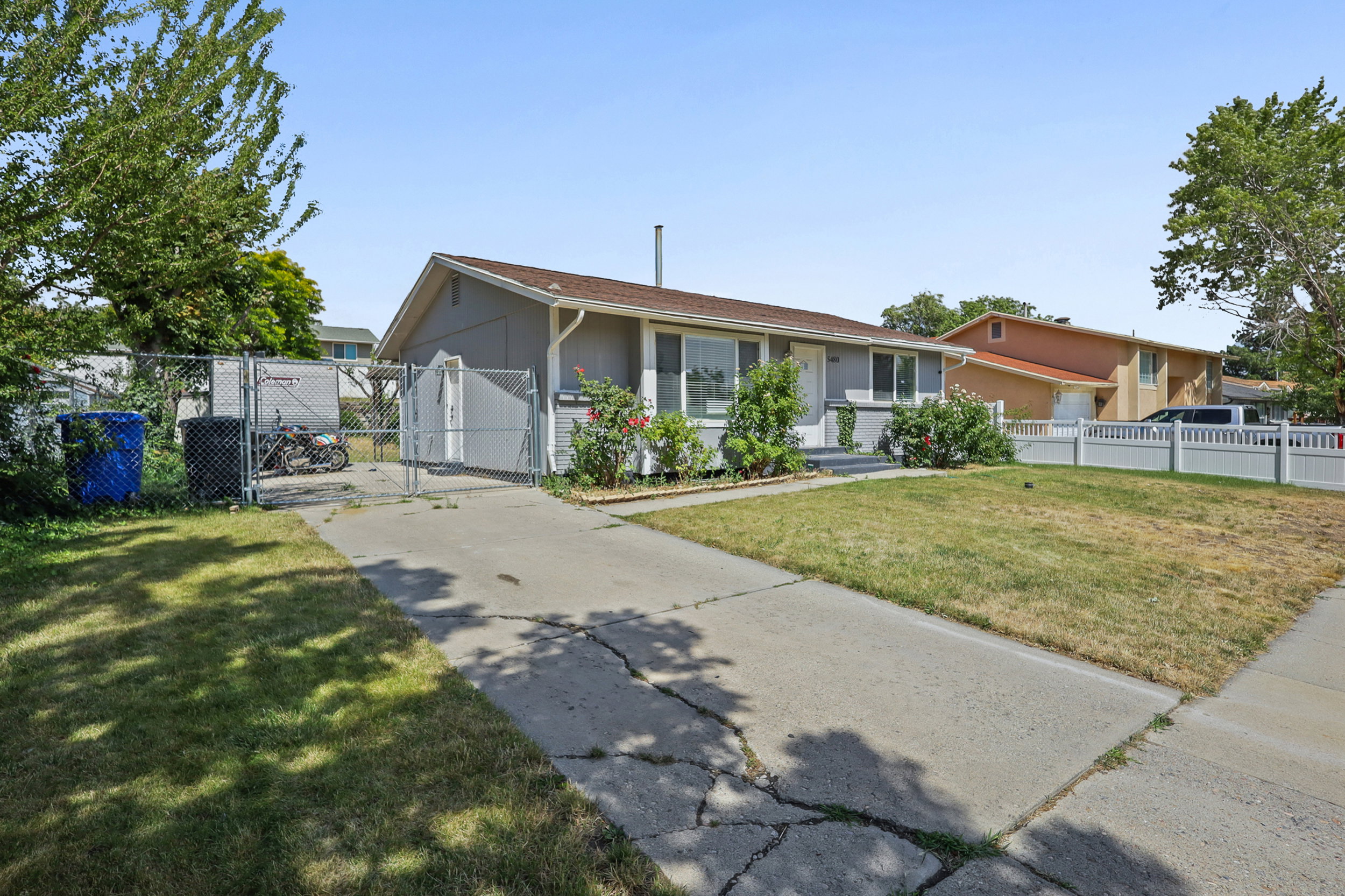 Ranch-style exterior with gray siding and white trim