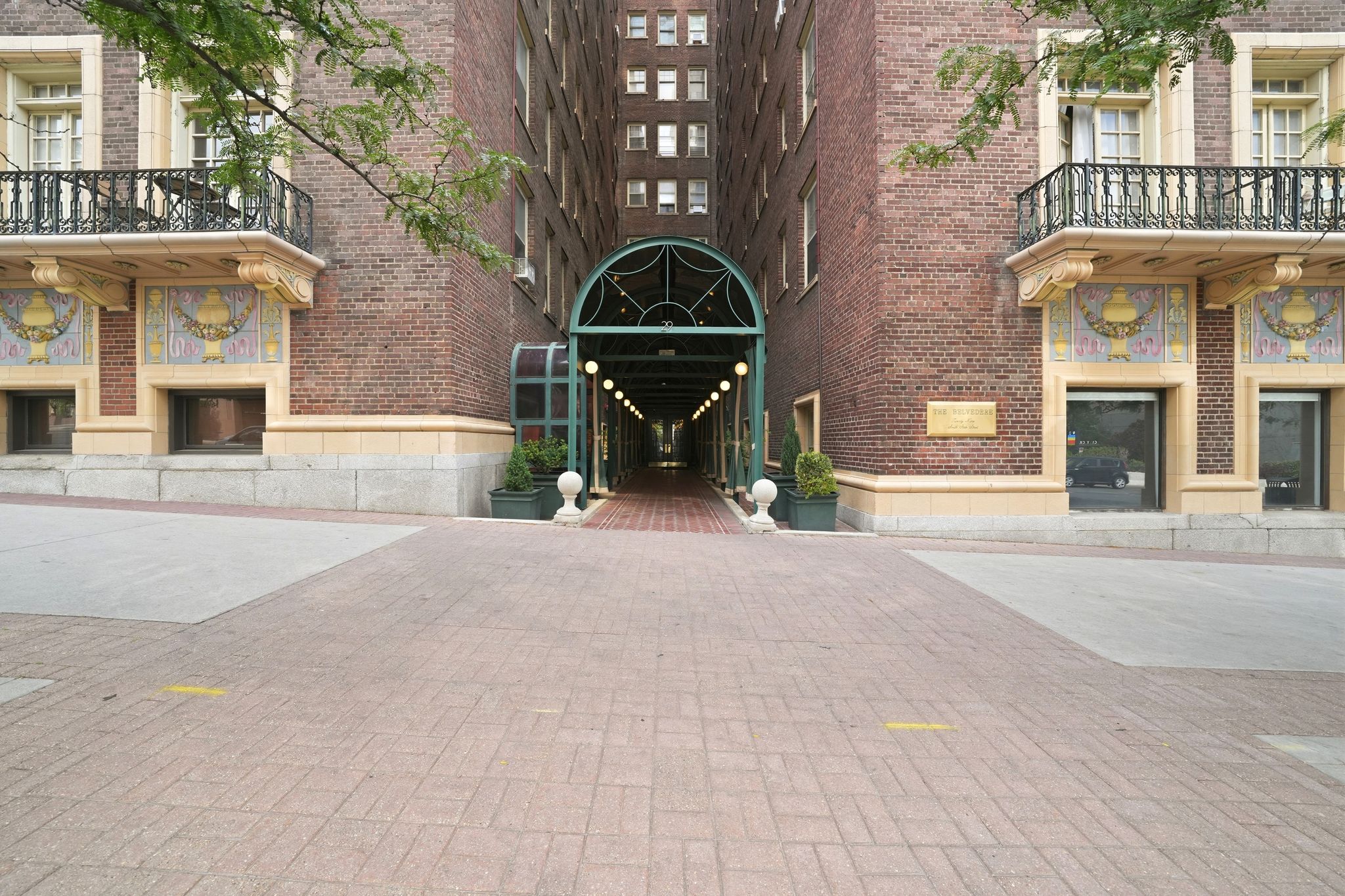 Brick facade building featuring an arched main entrance with an illuminated walkway