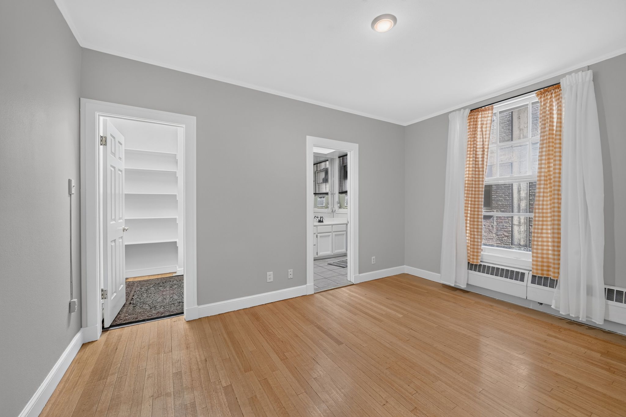 Hardwood flooring throughout this room with light gray walls and white trim