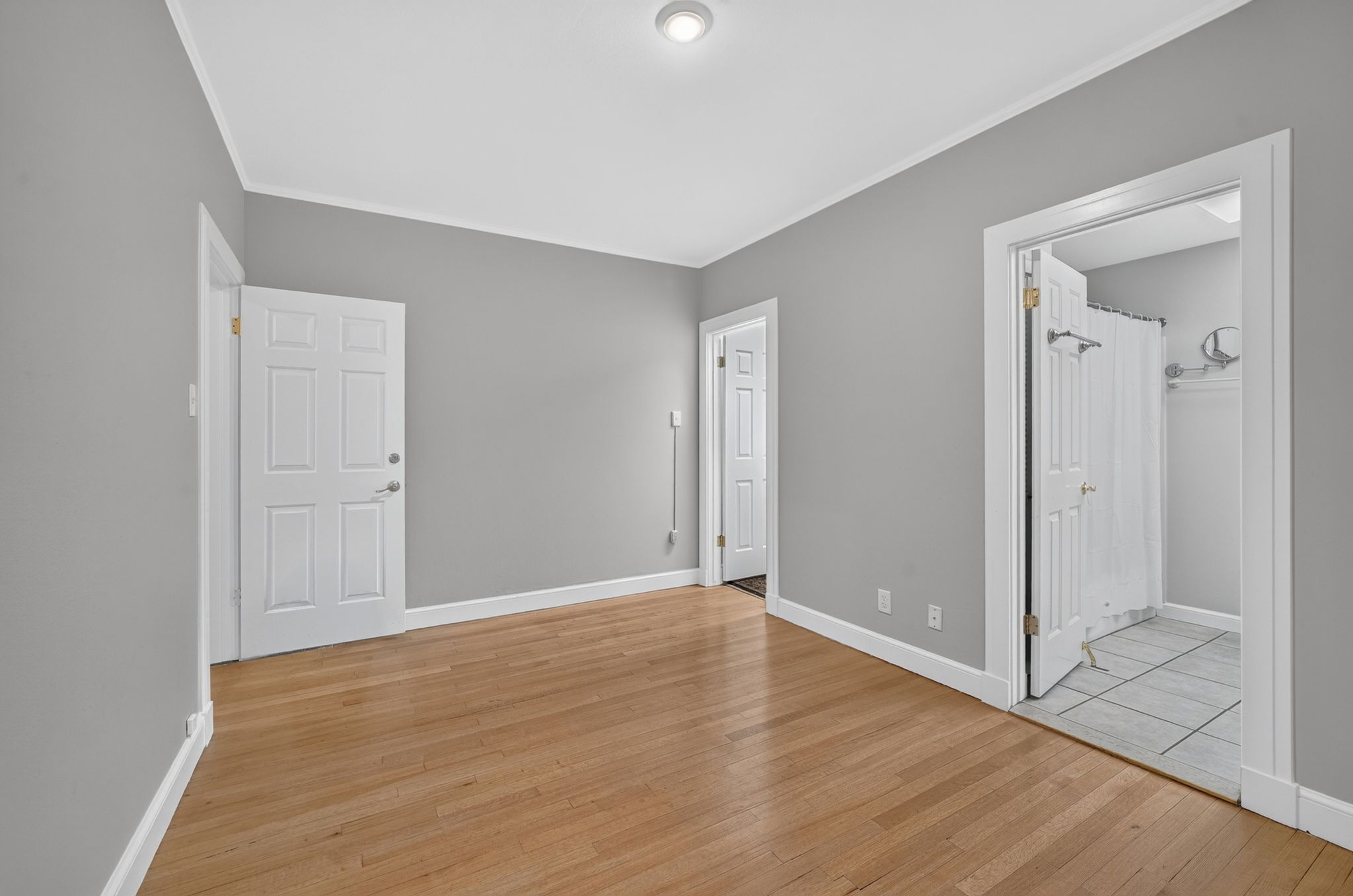Hardwood-finish flooring throughout, complemented by light gray walls and white trim